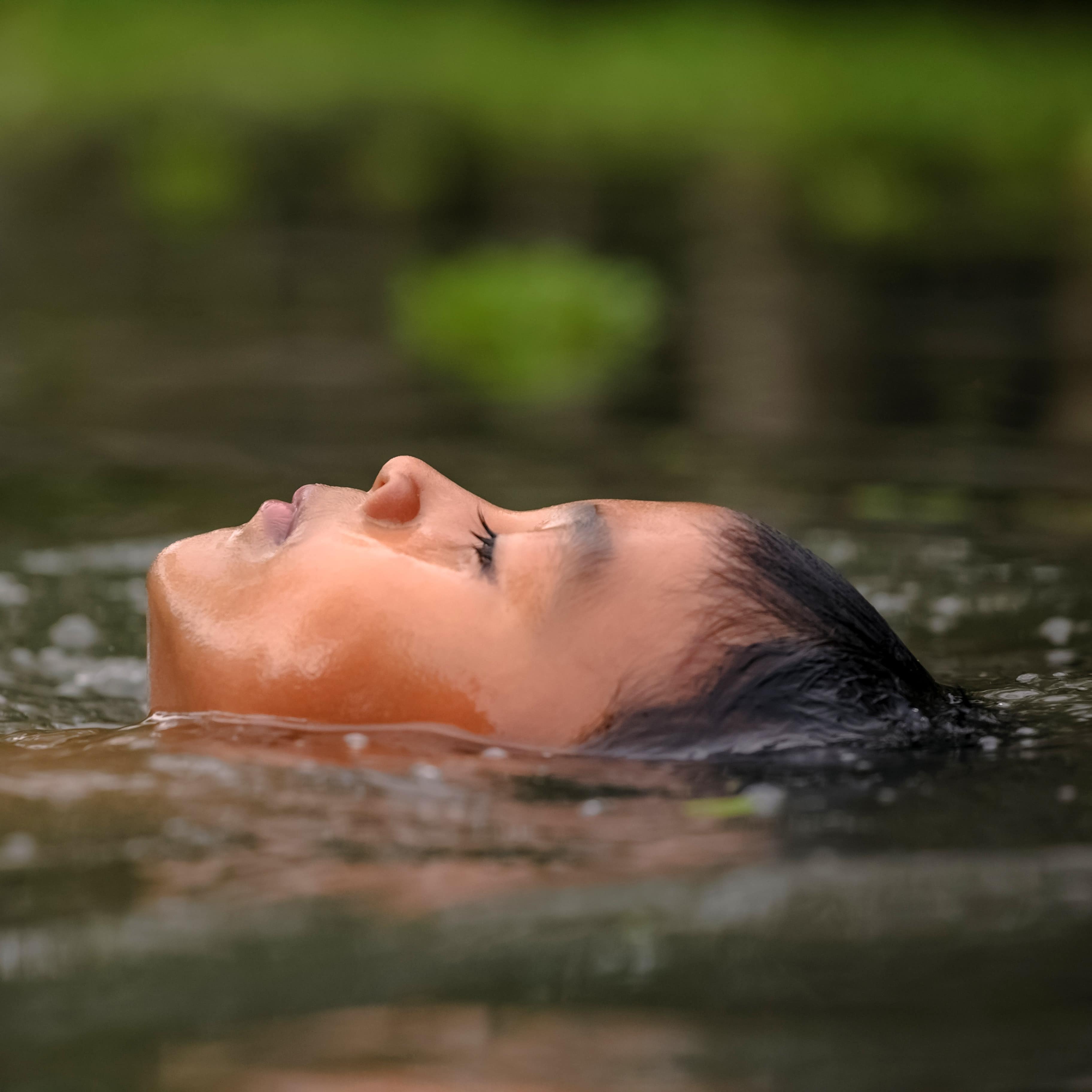 Young boy headshot floating peacefully in calm water