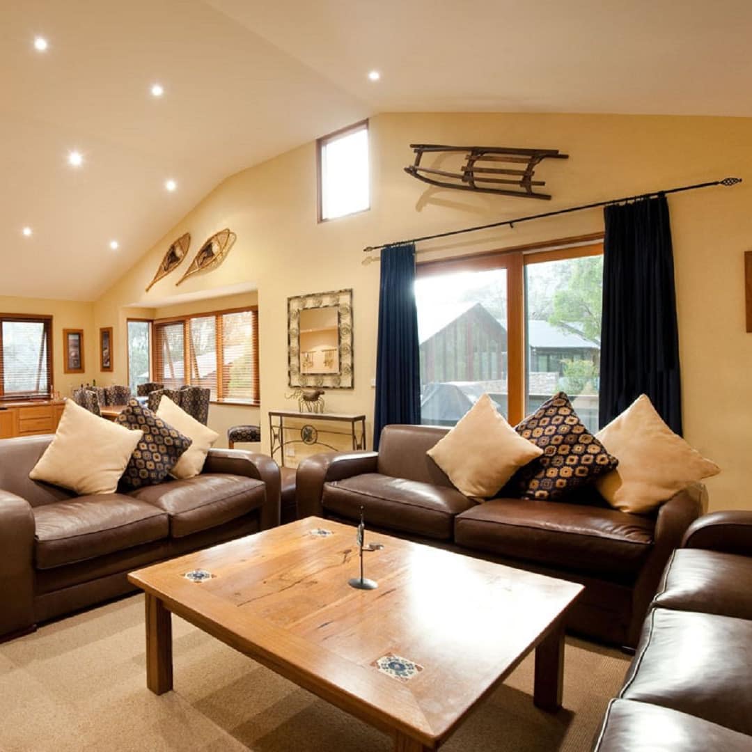 Living room of Kosciuszko National Park chalet with leather sofas and coffee table