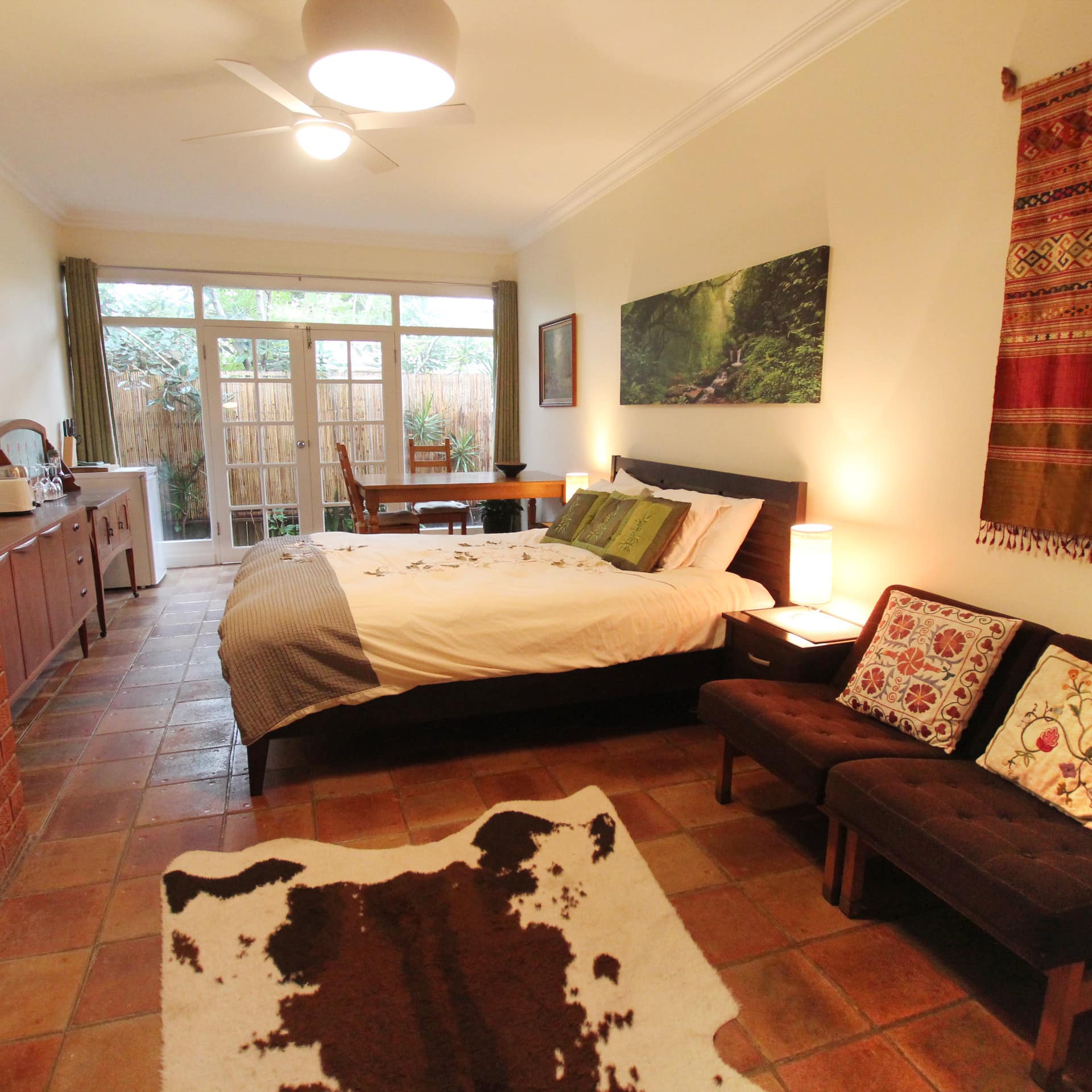 Western decor apartment bedroom with double glass doors that open to a small garden patio