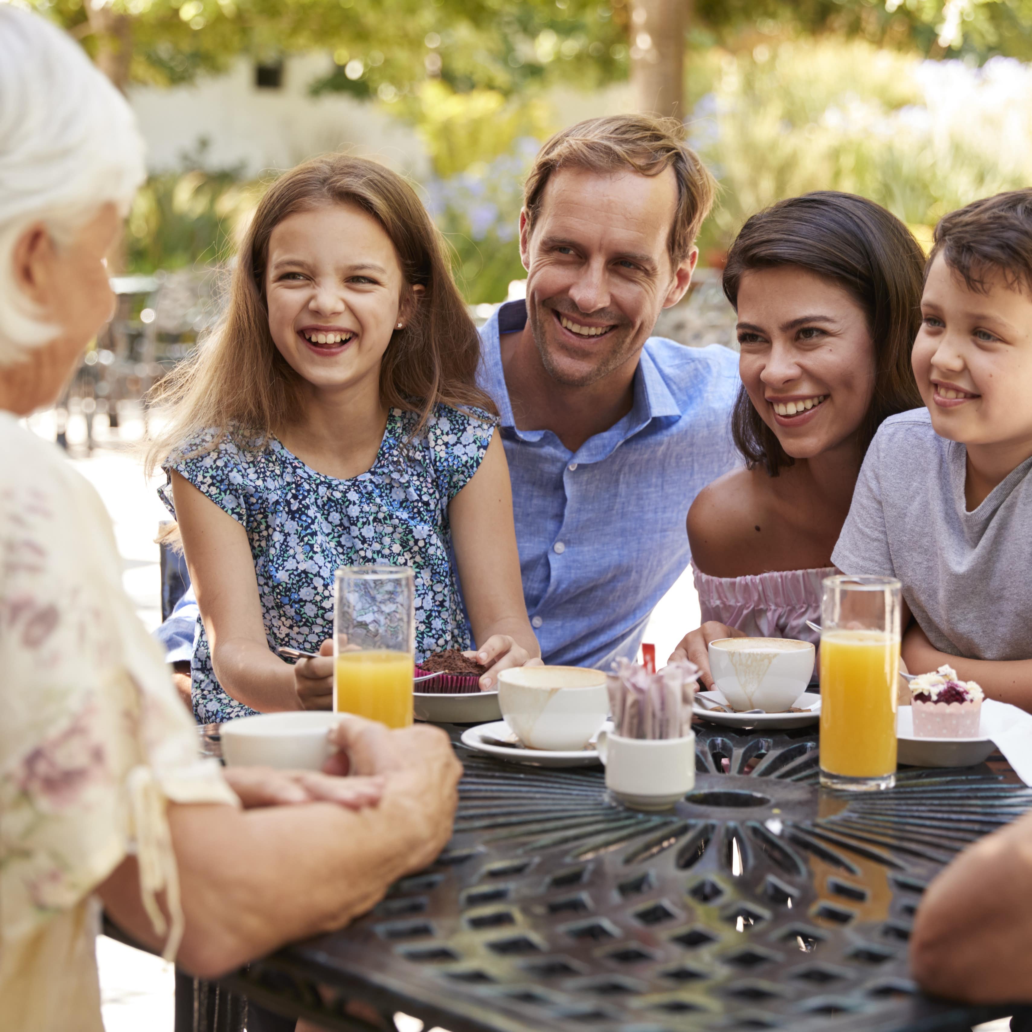 Multi generation family enjoying snack at outdoor cafe together