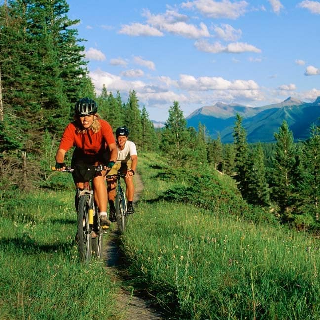 Couple on bike trail with mountain range in the background