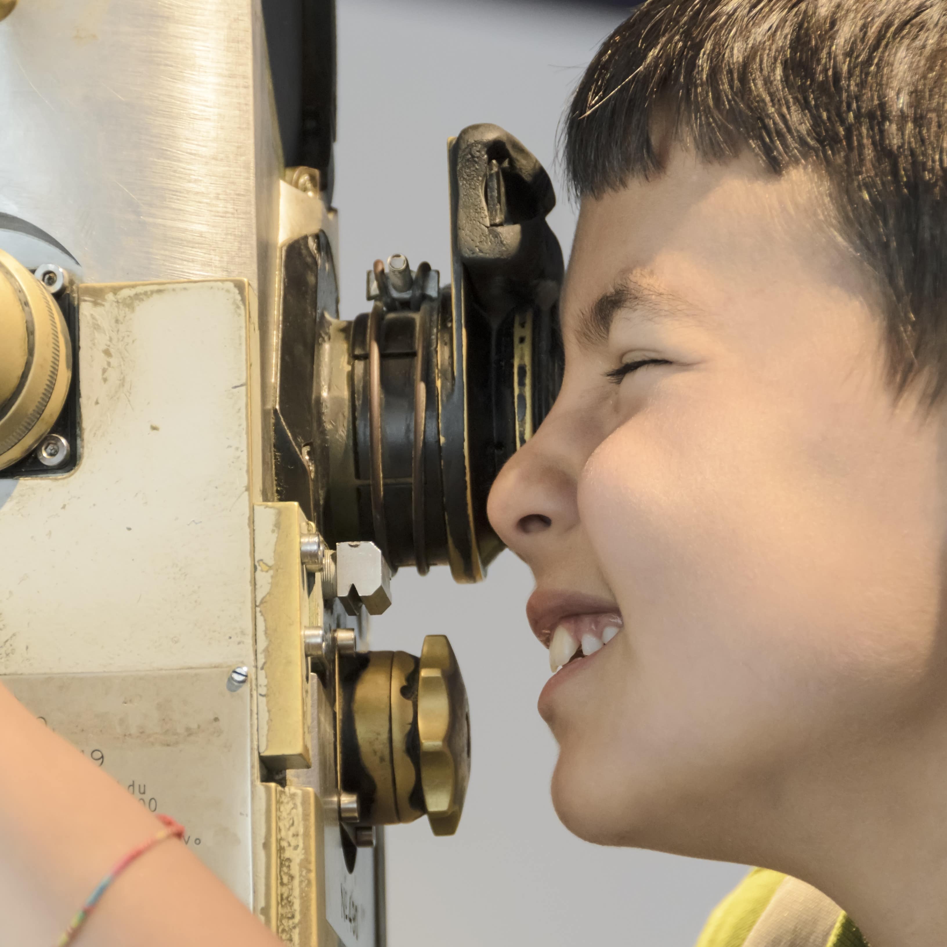 Young boy looking through a periscope on submarine