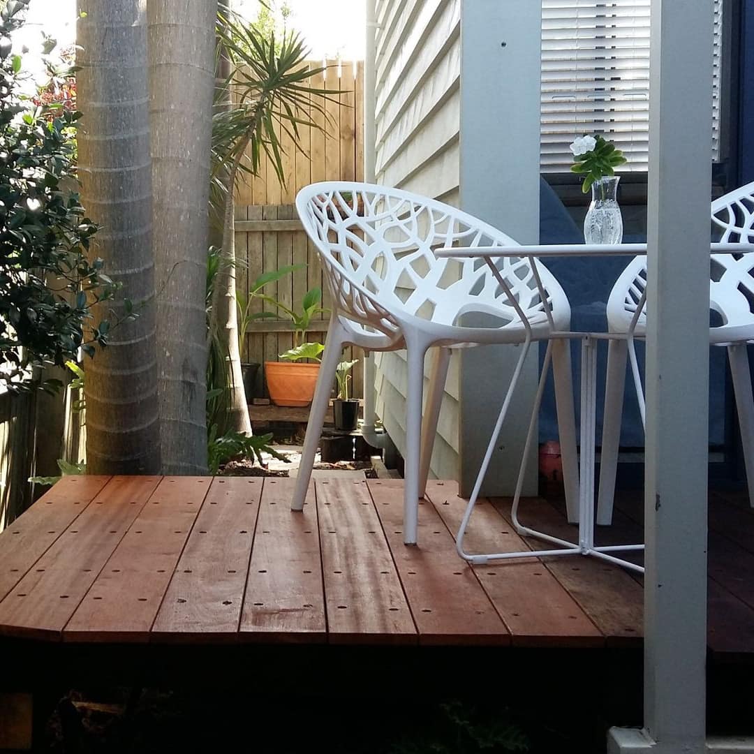 Bungalow porch with small white table and chairs surrounded by bamboo