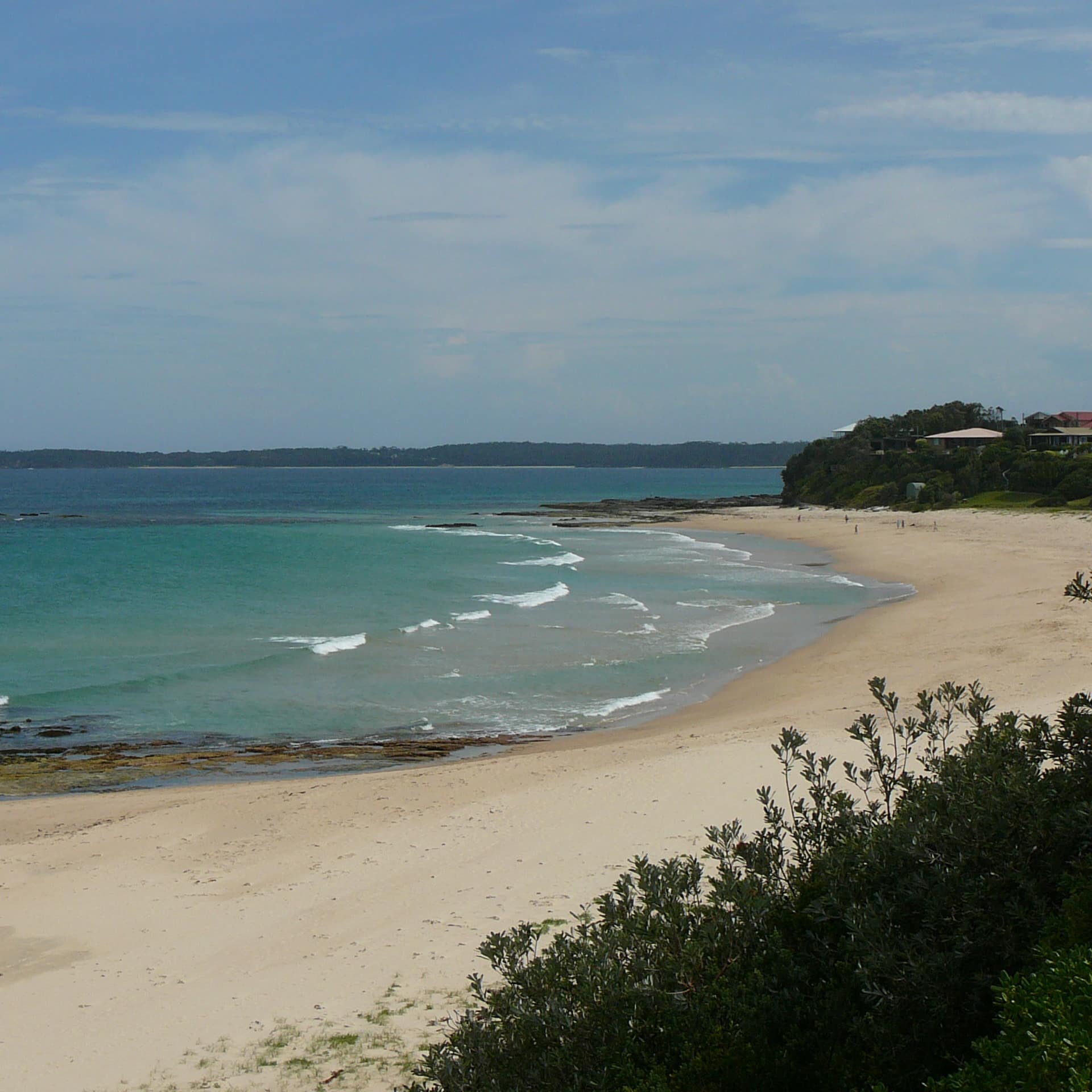 View of lovely Kirby’s Beach with clear, azul waters and wide, white sands within walk from Mollymook beach cottage