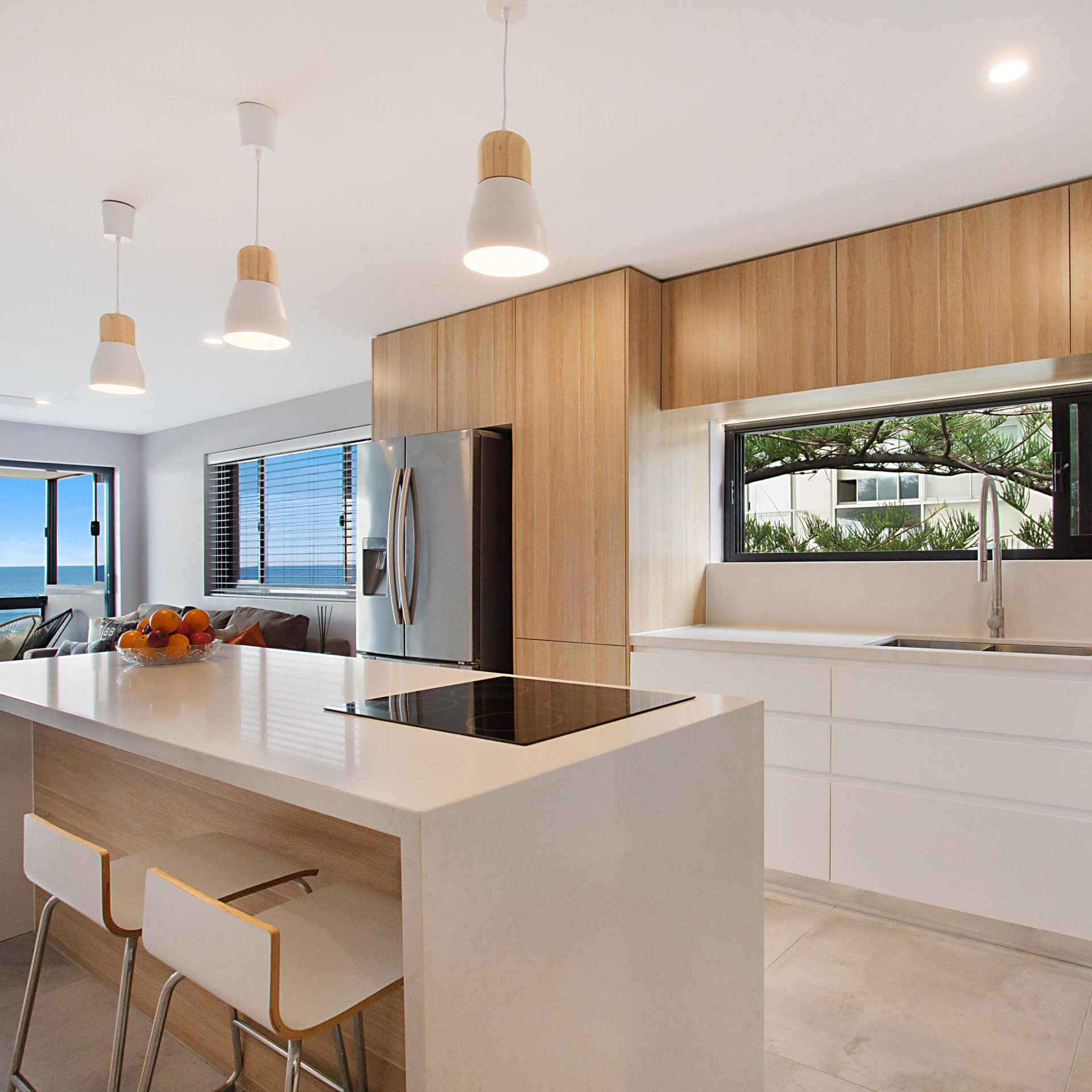 Modern kitchen in luxury holiday apartment with stainless steel appliances and an eat-in bar with ocean view