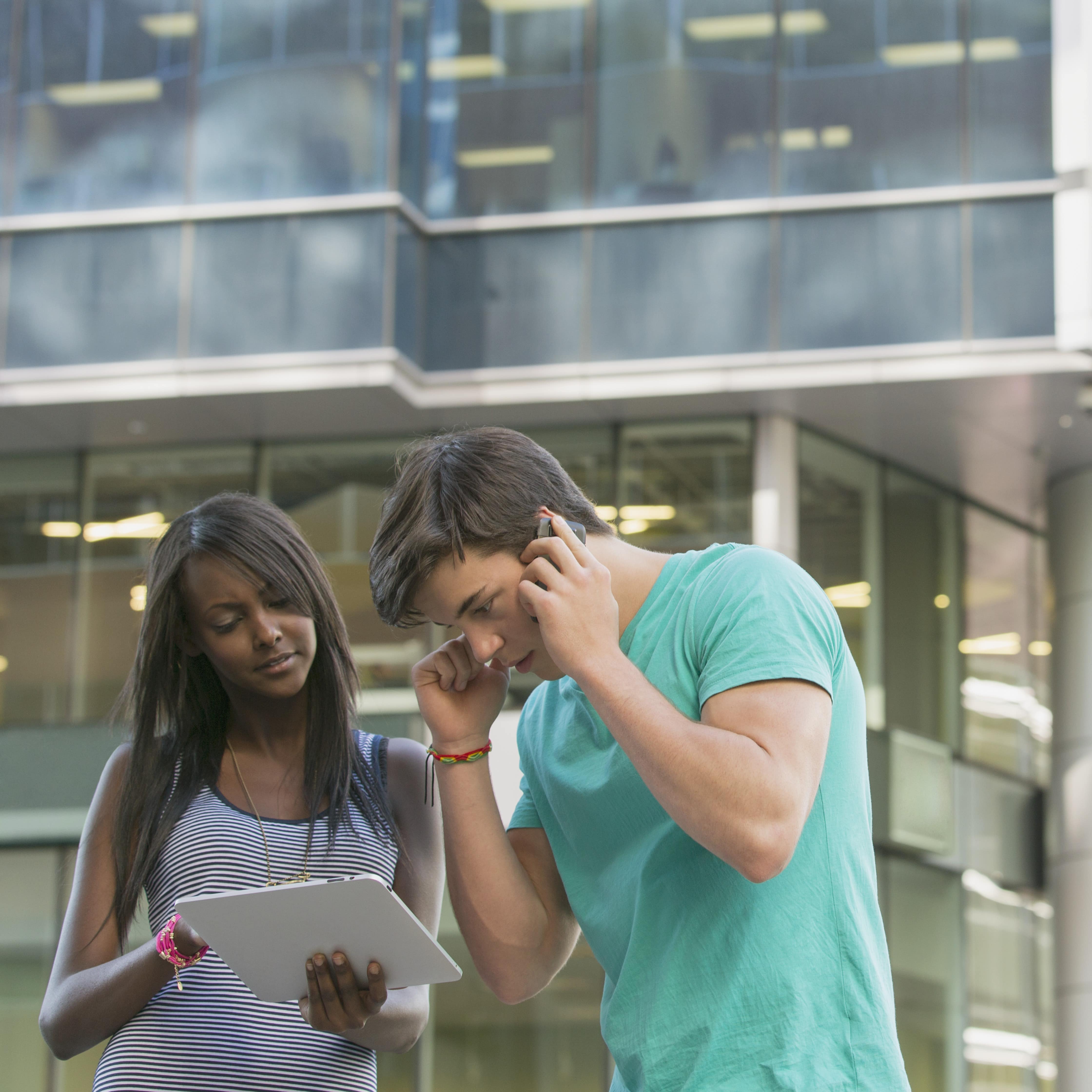 Two teenagers using technology app and following directions for guided tour