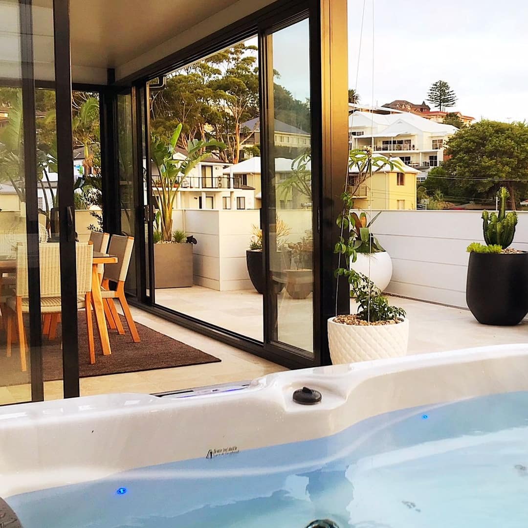 Landscaped balcony with hot tub and open dining area