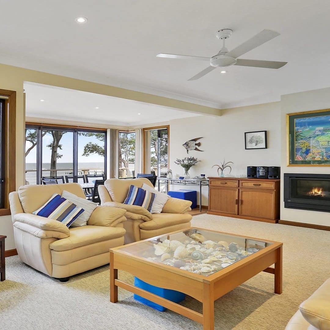 Spacious and bright living area with a fireplace and gorgeous views of the water through the large windows