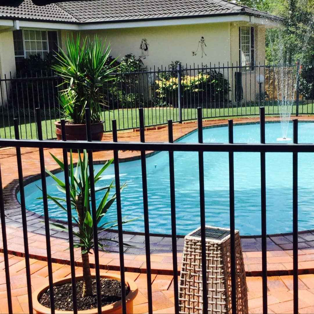 Kidney-shaped pool with fountain surrounded by terra cotta bricks at stylish 2-bedroom villa