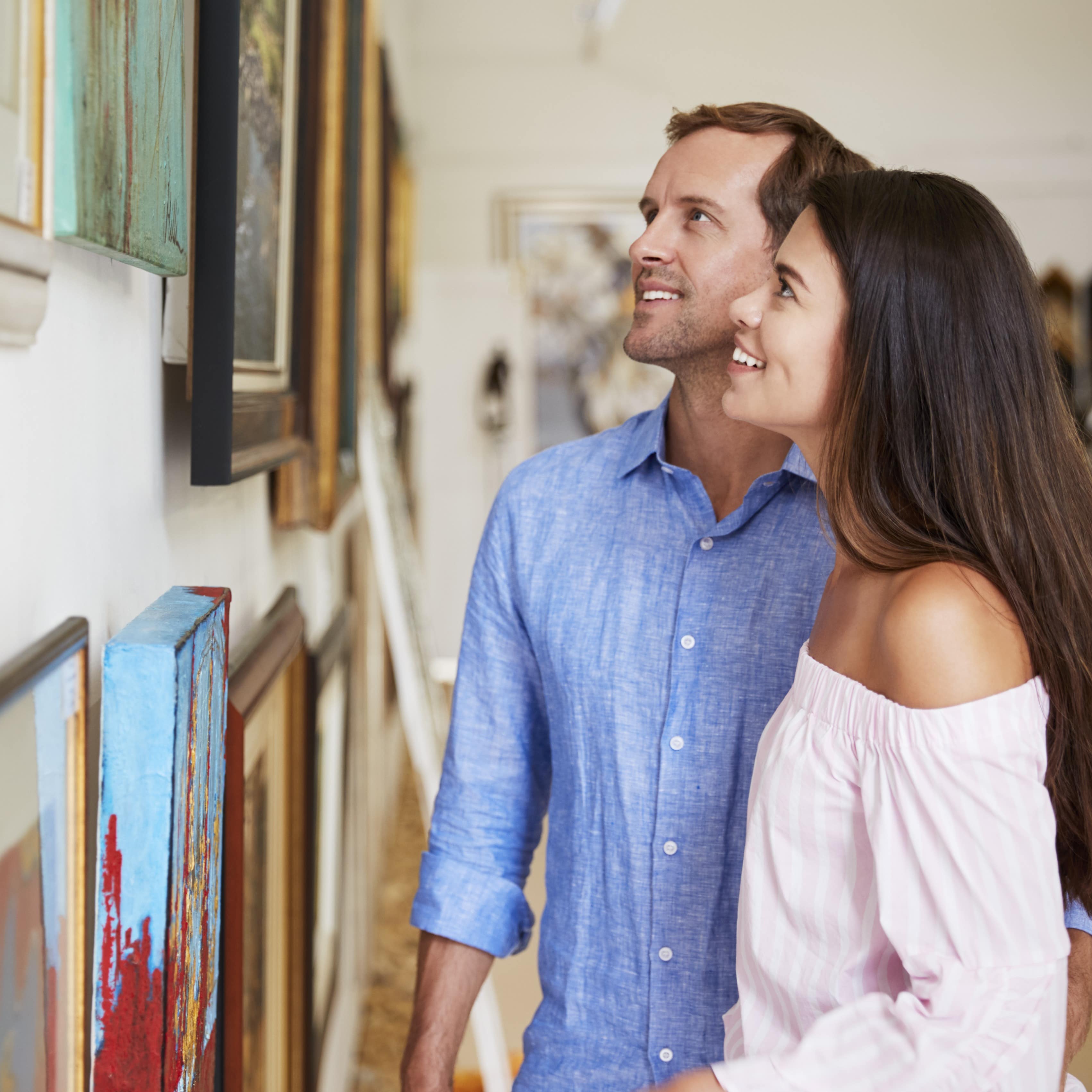 Couple looking at paintings at gallery