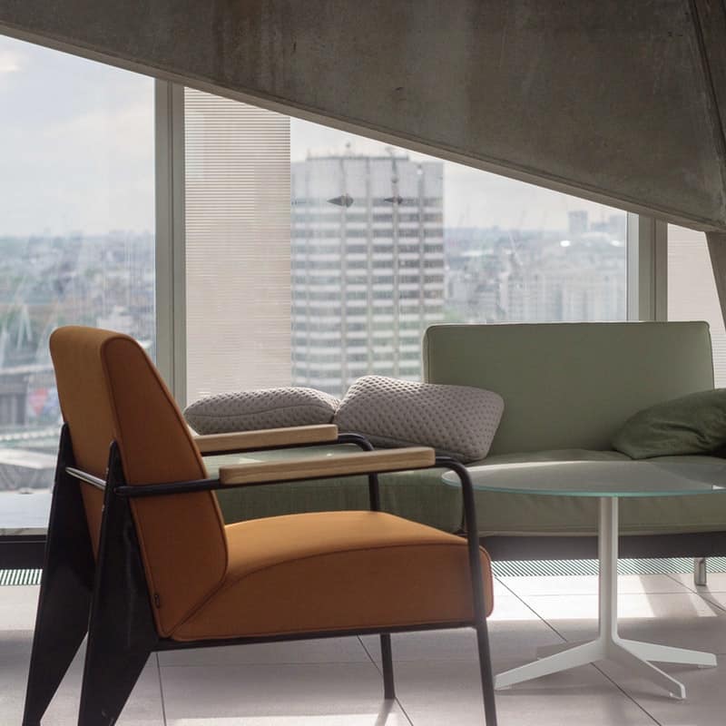 Modern chairs and tables on white tile floor in modern high-rise apartment overlooking the city