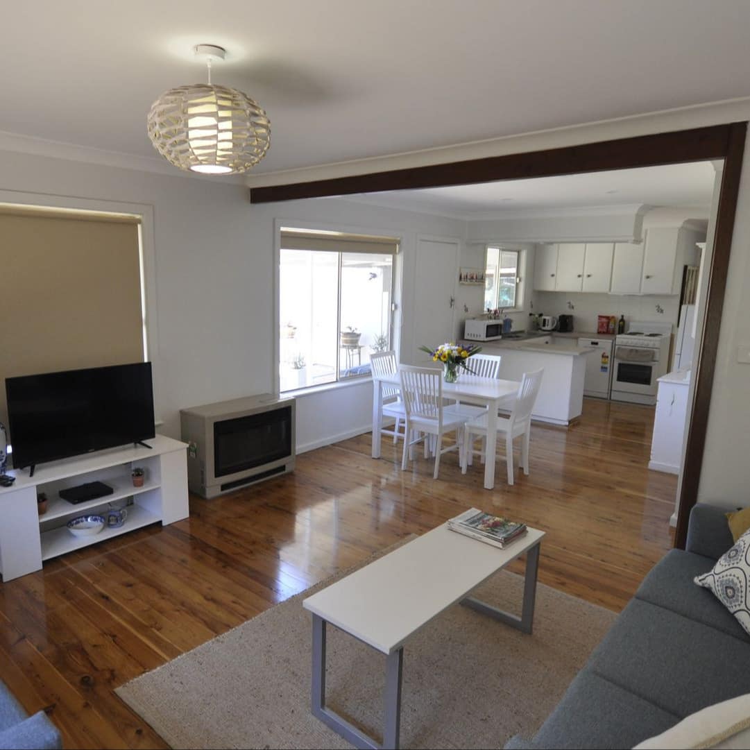 Spacious and bright living room looking into open kitchen and dining area