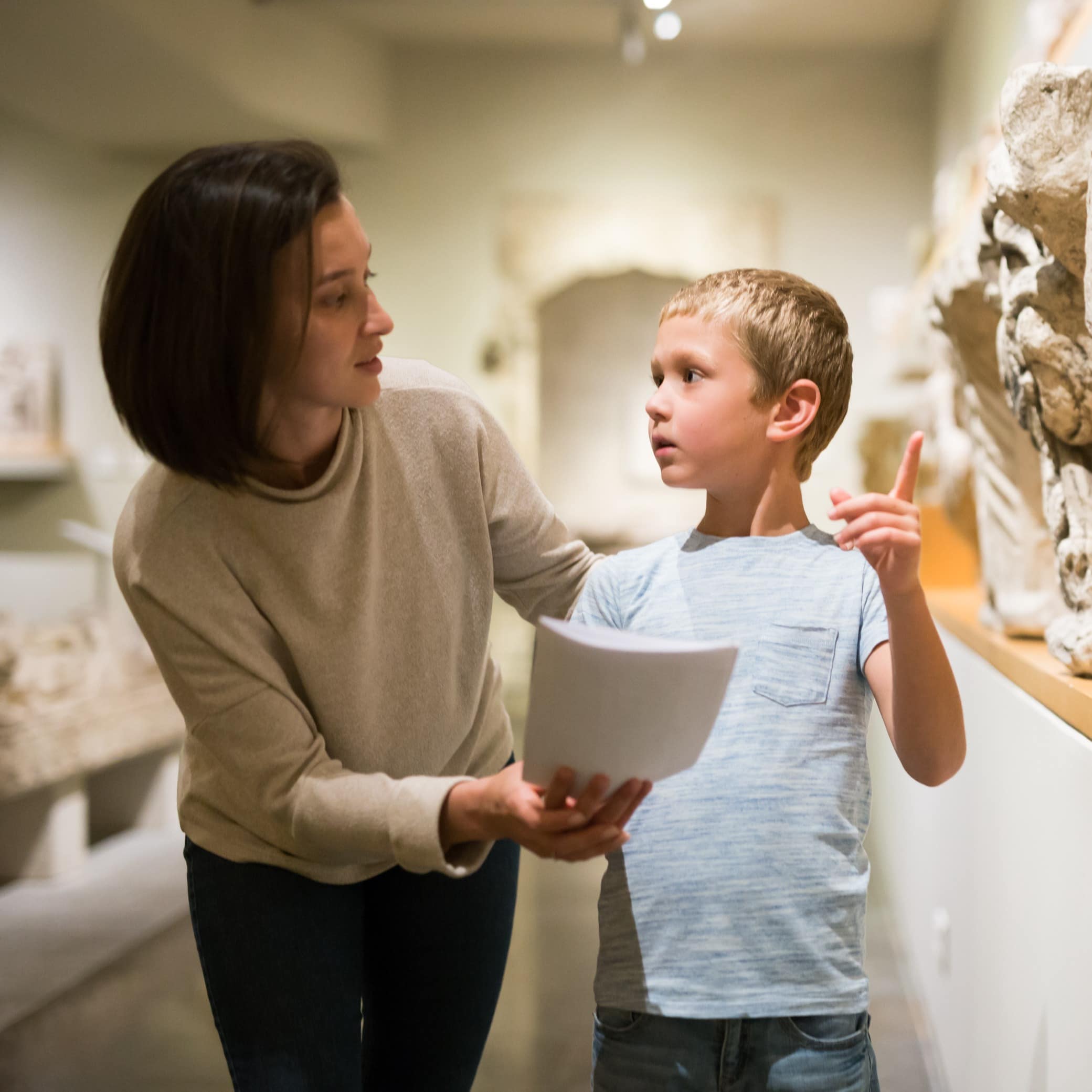 Woman and boy observing sculptures exhibition
