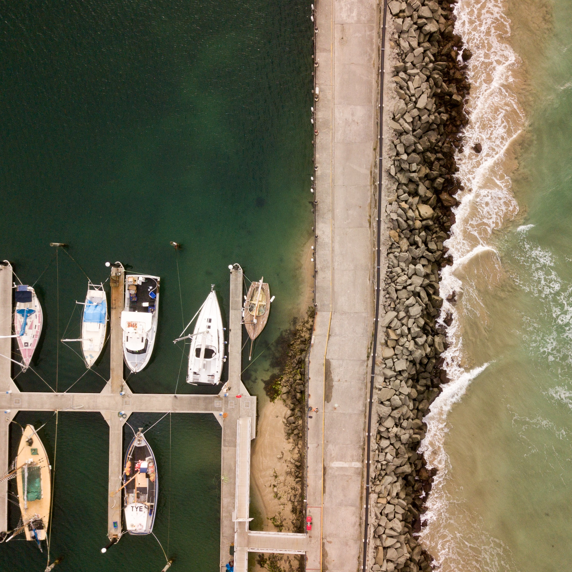 Aerial view of green waters of Apollo Bay with docked sailboats