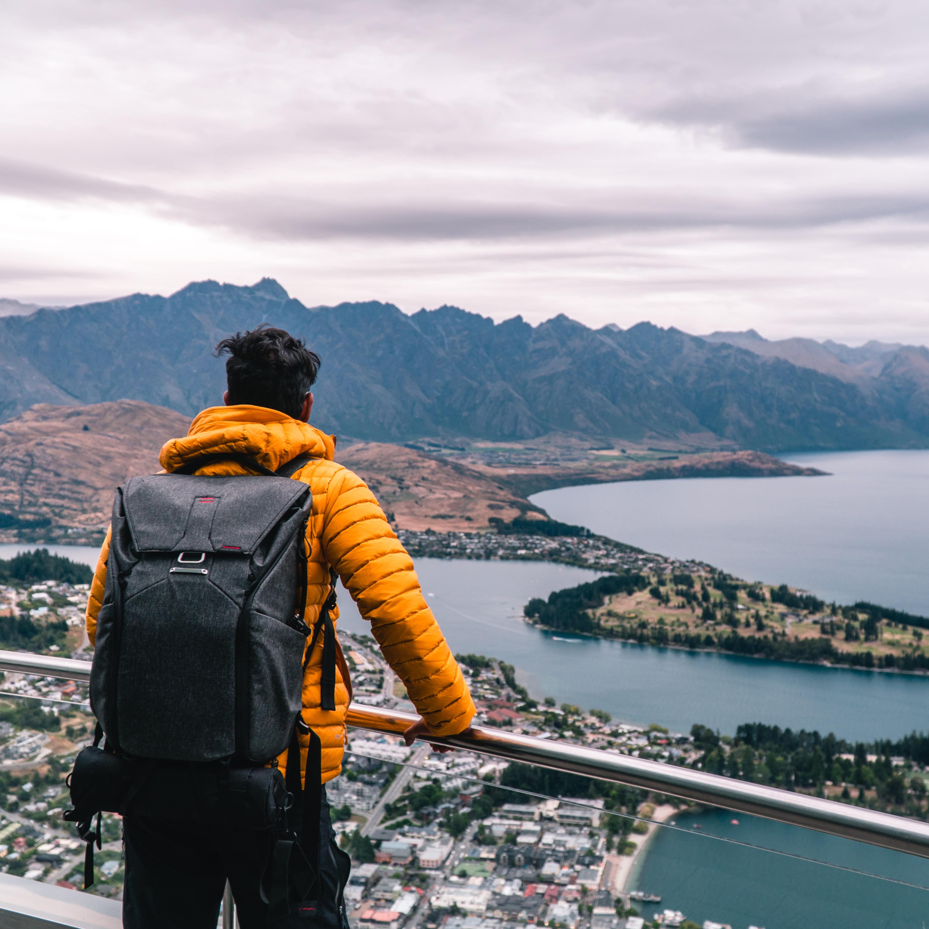 Man wearing a backpack overlooking Queenstown