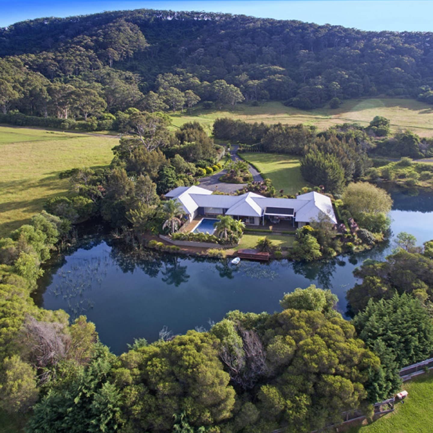 This sprawling and secluded country house sits right on a lake and has its own private cove surrounded by trees