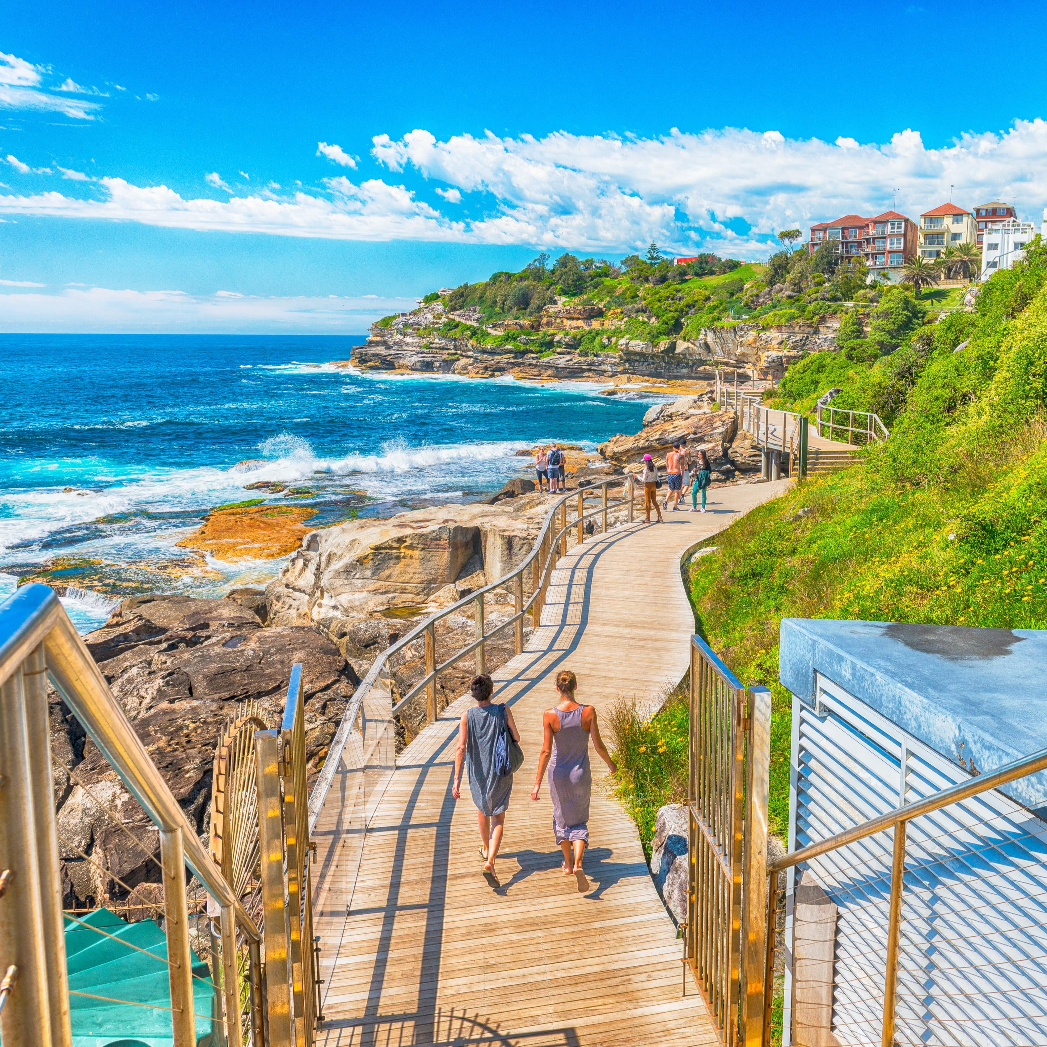 People walking along boardwalk beside Bondi Beach