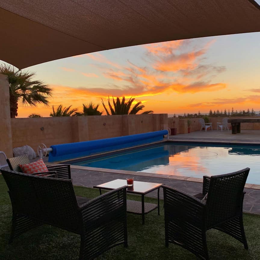 View of seating area and private pool at Rockingham bed and breakfast with lovely sunset