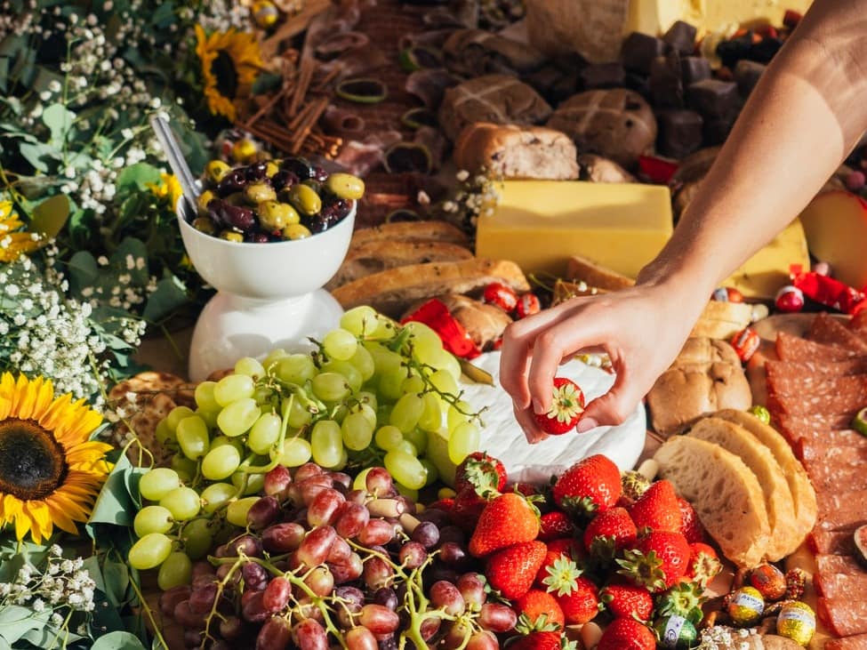 photo of a table overflowing with fresh fruits and charcuterie