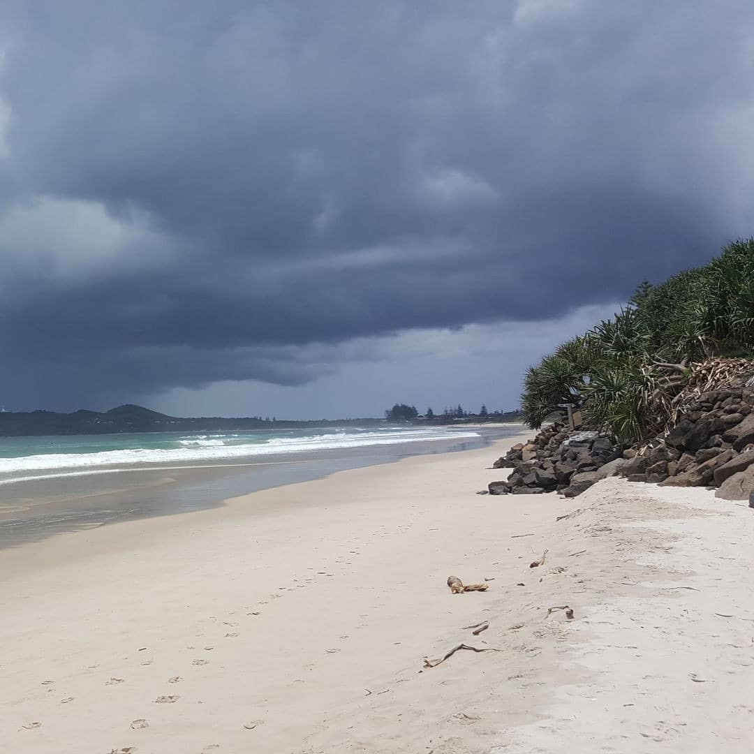 Byron Beach views with white sands, surf and distant hills