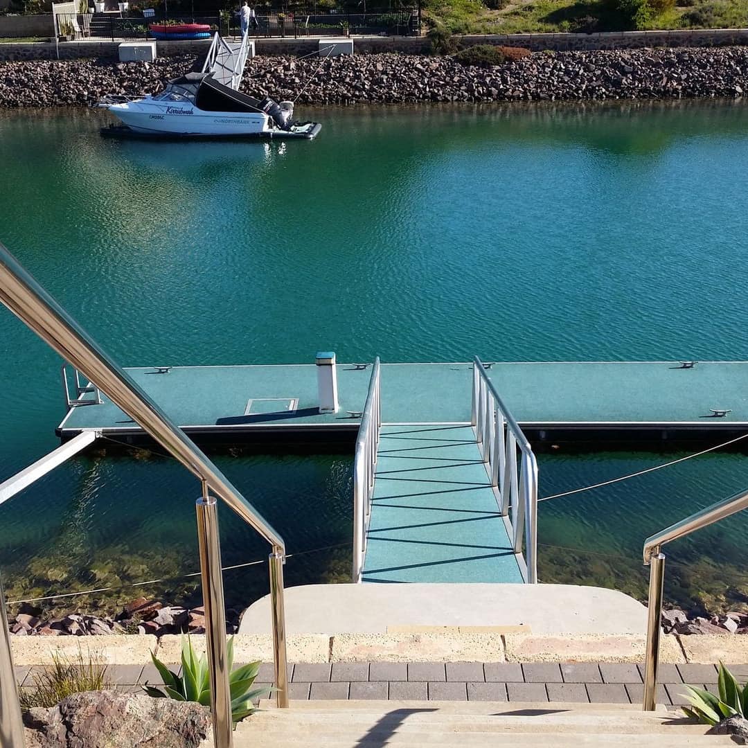View of private dock on the canal with stone staircase from the home to the dock.