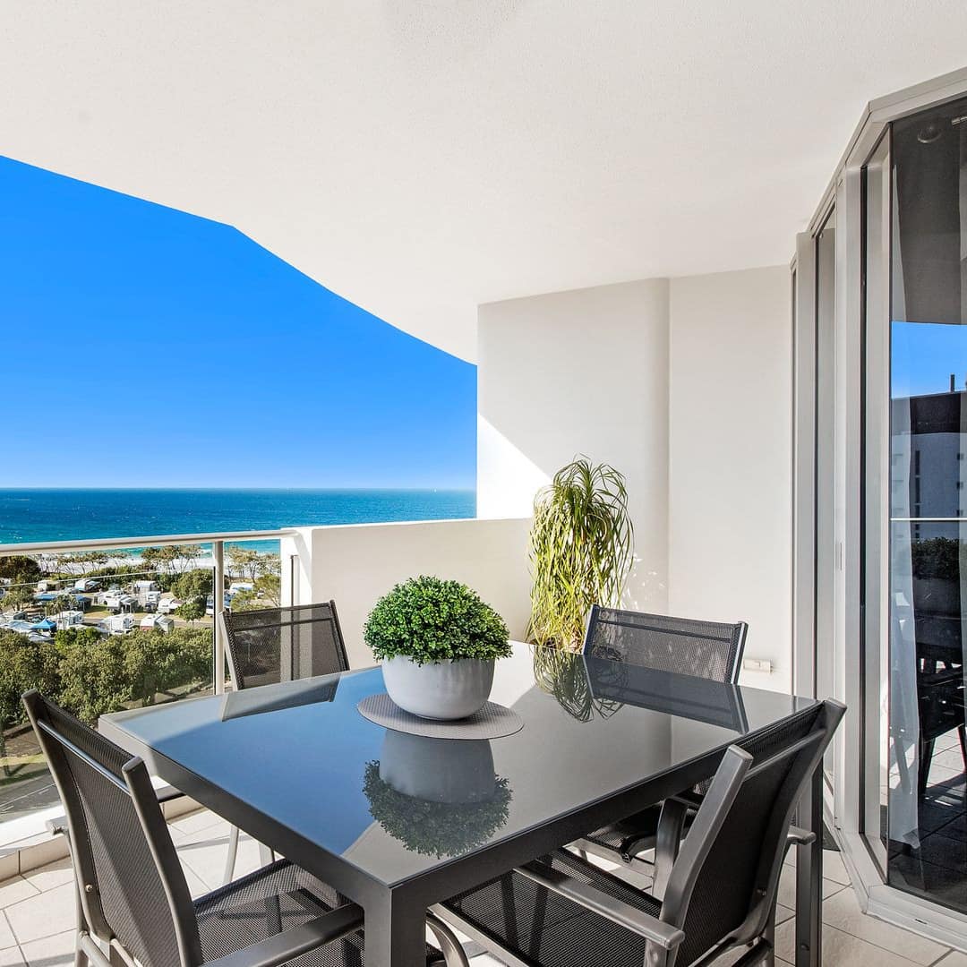 Balcony of 9th-floor, 2-bedroom apartment with 4-seater al fresco dining and views of ocean in the distance