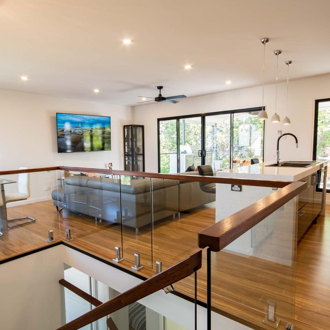 Kitchen, living and dining room in a modern, open home with hardwood floors, white walls, and modern furnishings.