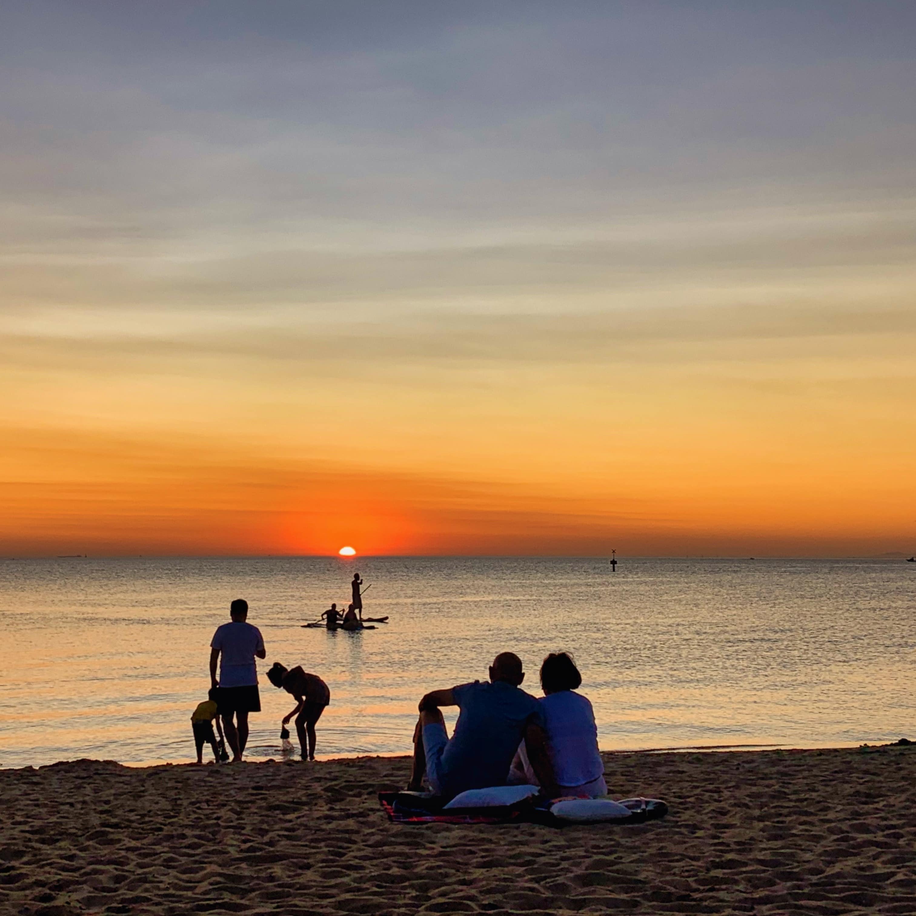 Silhouettes of people watching the sunset at St. Kilda Beach