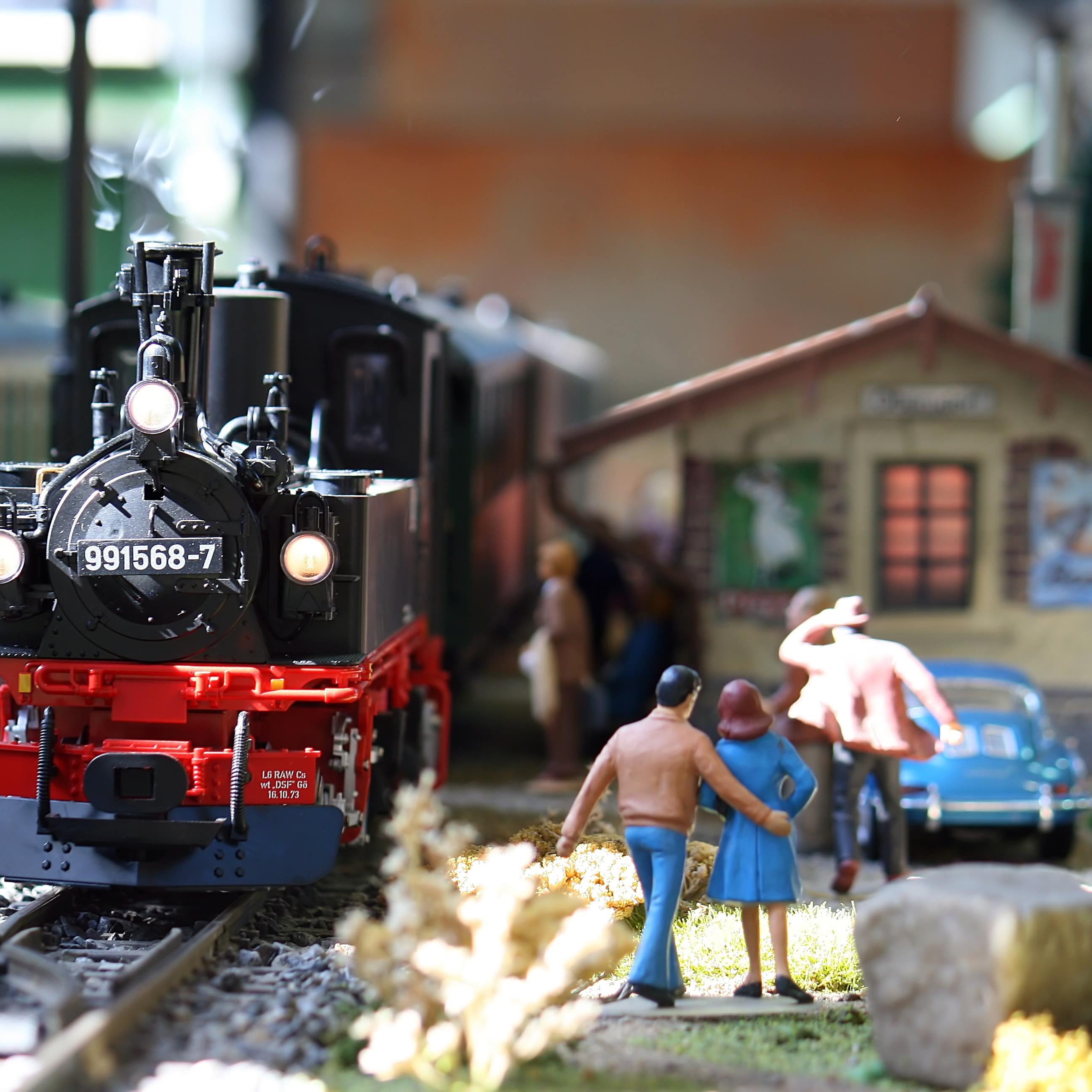 Close up of a model train exhibit with black engine and people