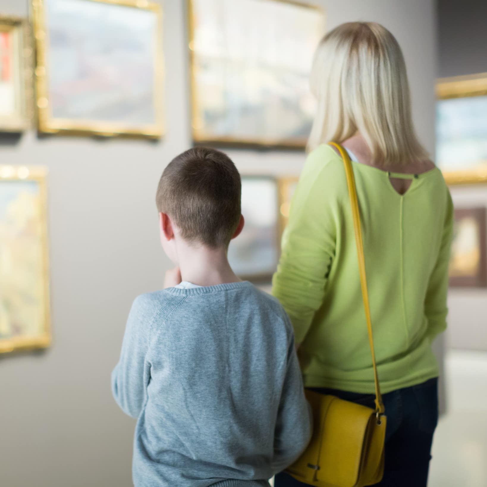 A mother and son exploring paintings at museum