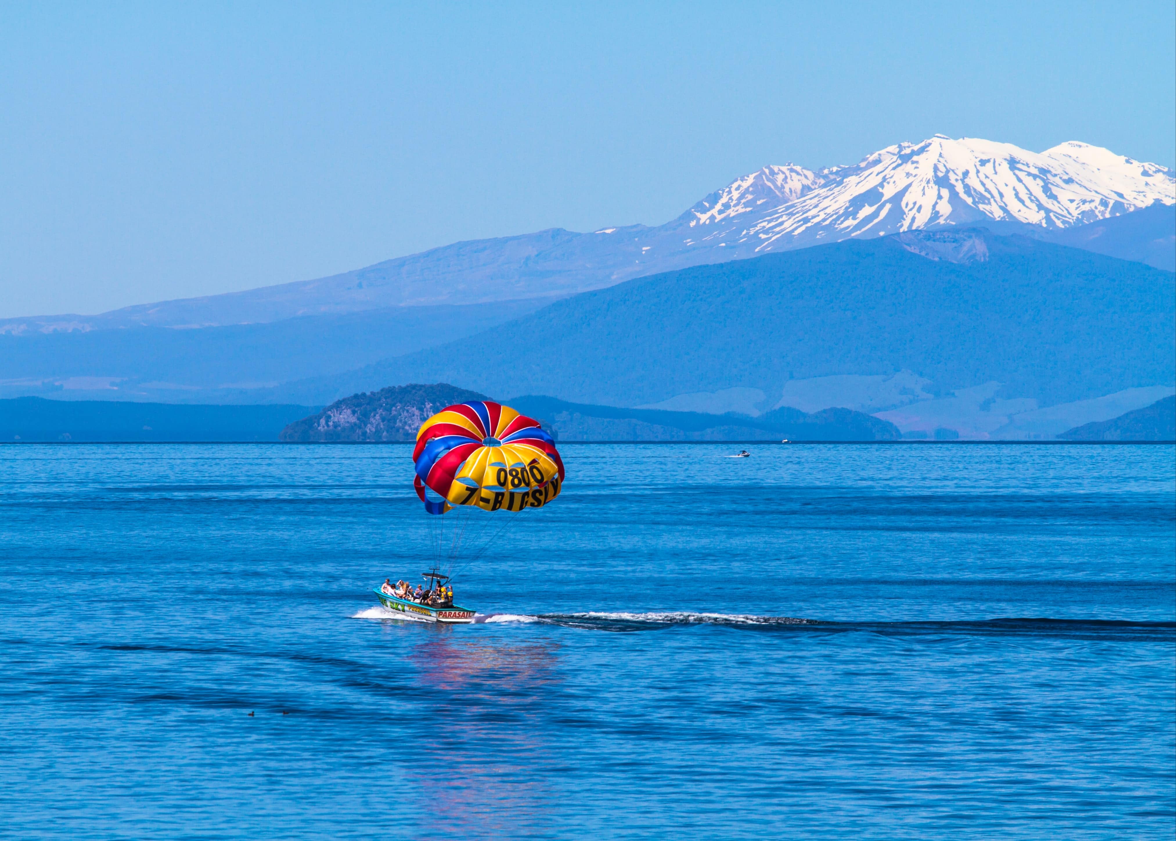 boat on lake taupo new zealand with parasailing family