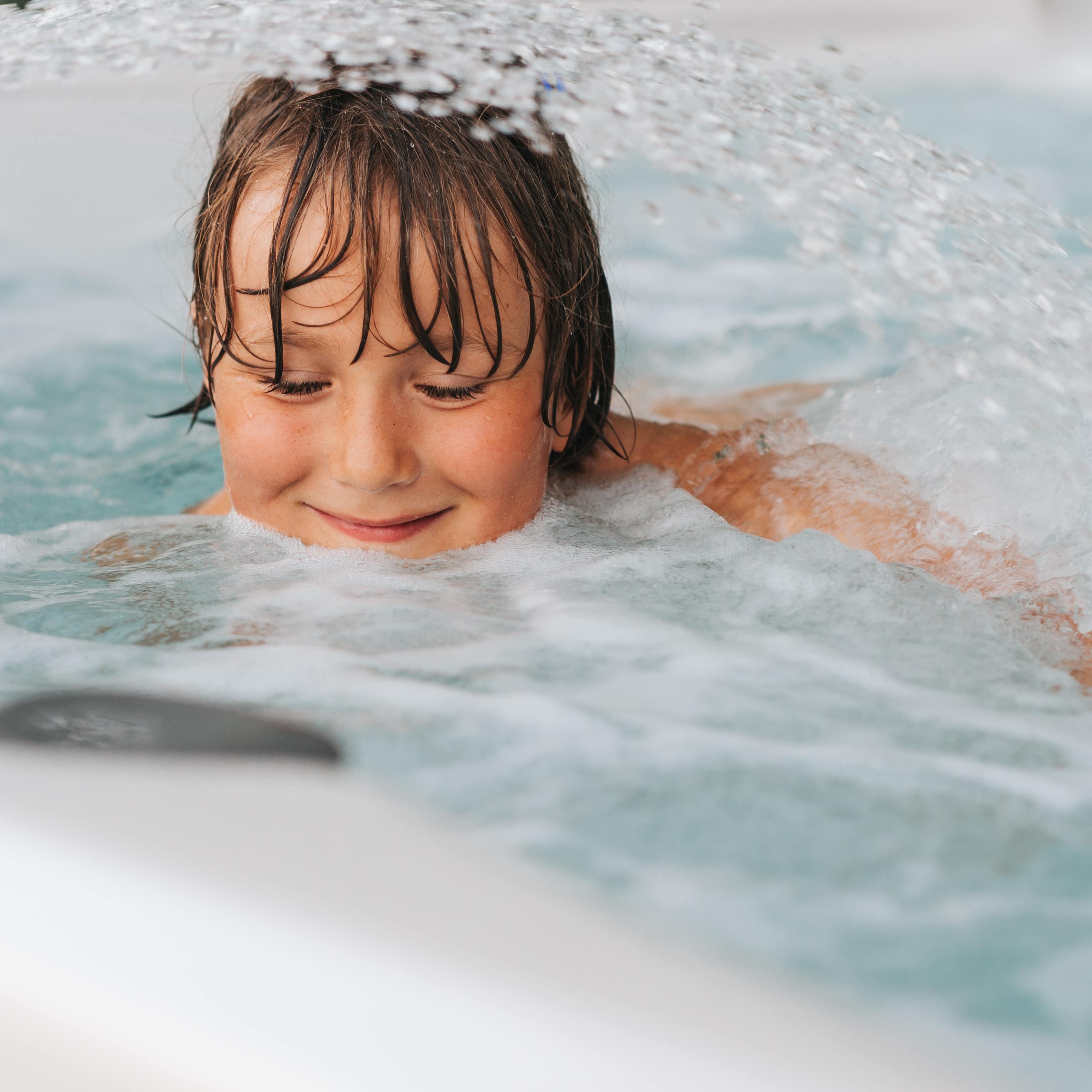 Child enjoying the water in a hot tub