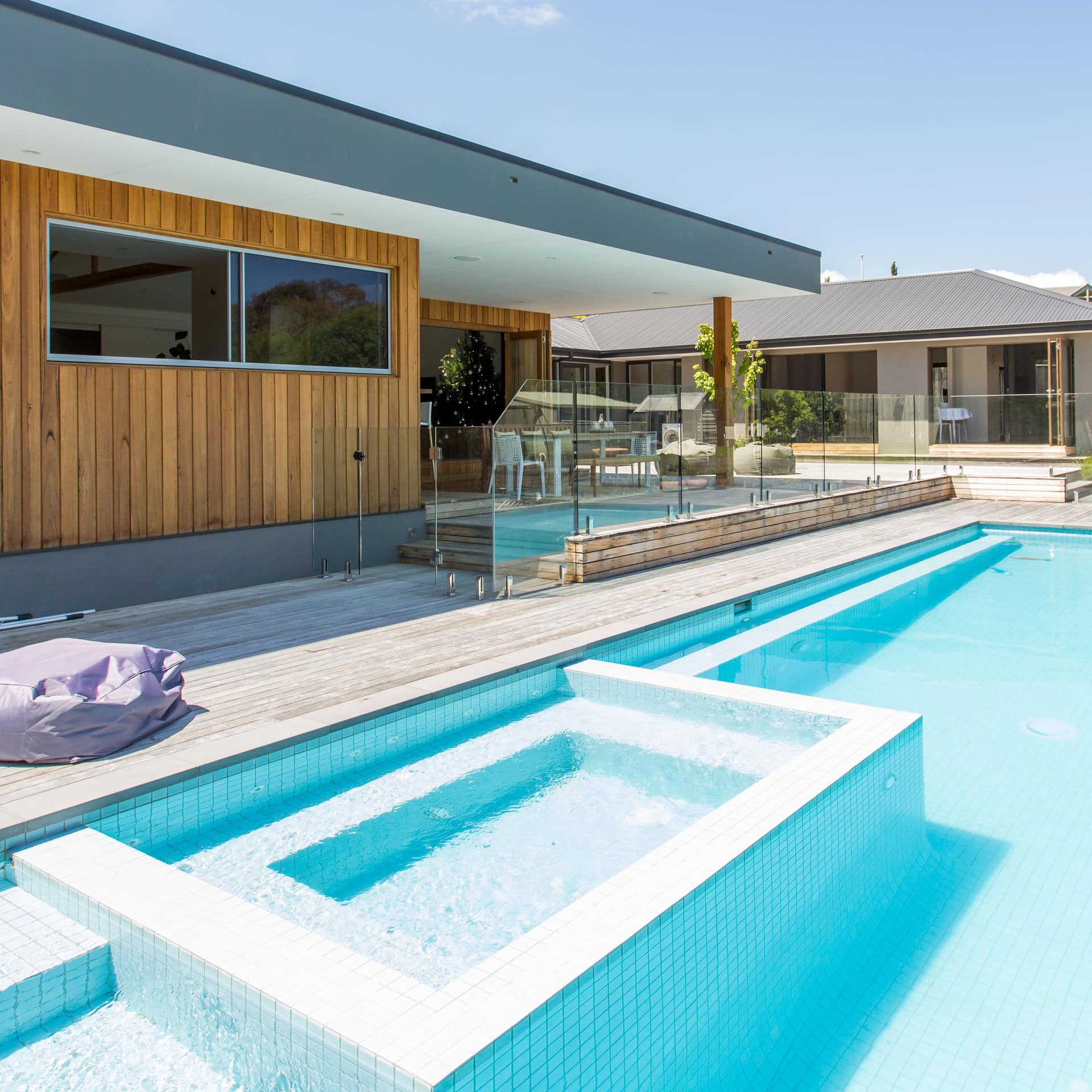 A clear private swimming pool, hot tub and modern wood building provide luxurious surroundings in this villa