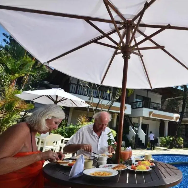 Older couple enjoying breakfast by the pool