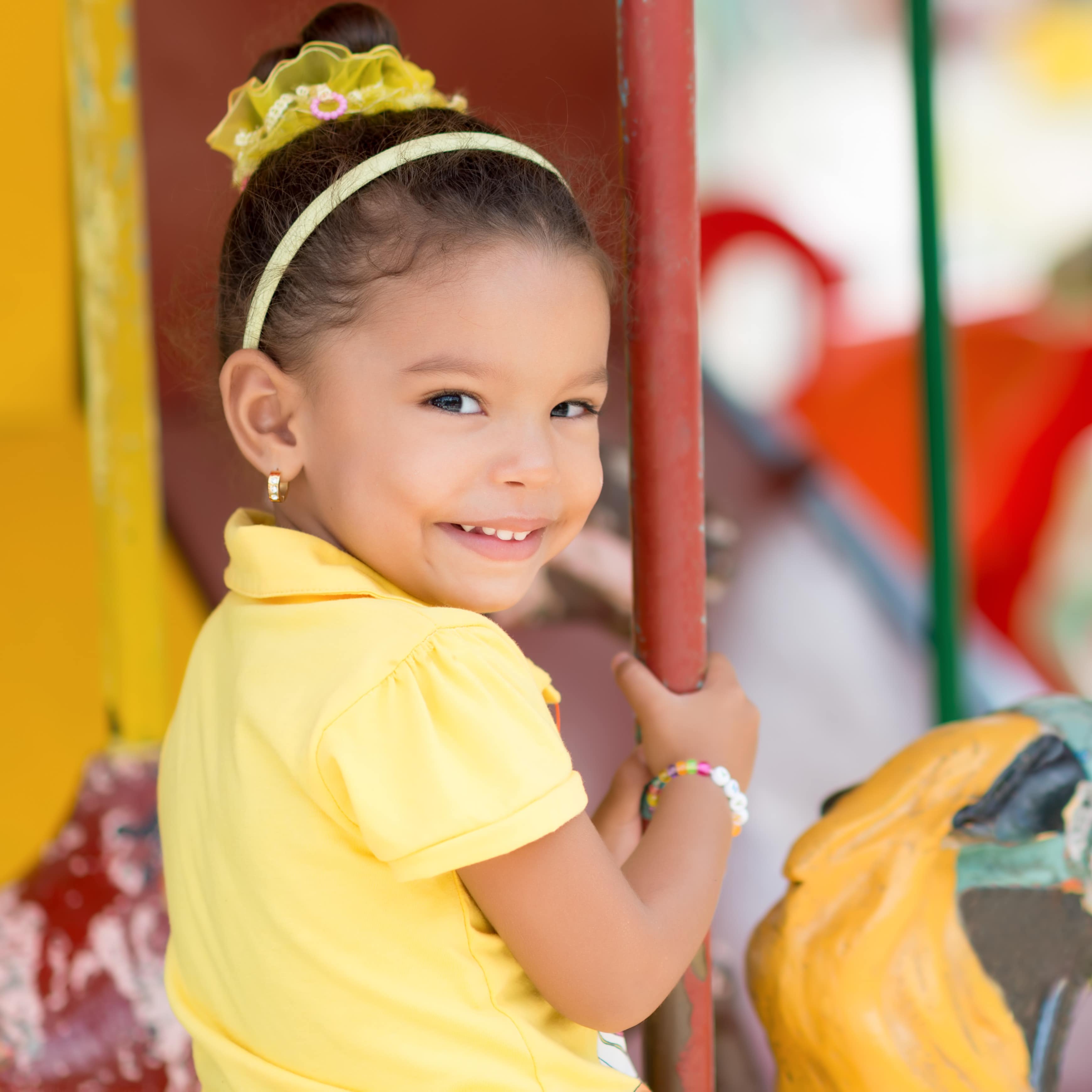 Little girl riding carousel