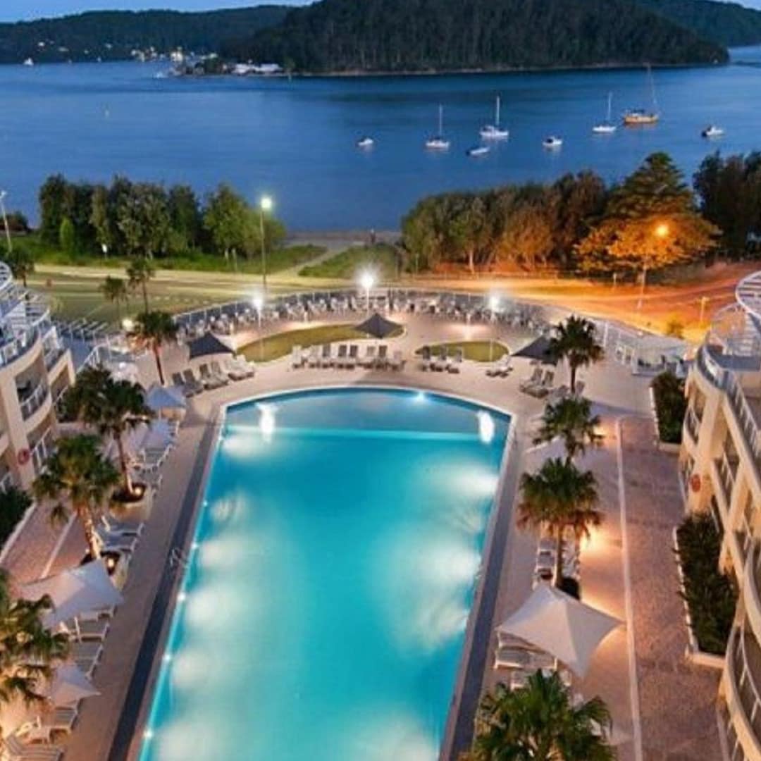 Balcony view of ocean and illuminated pool at night