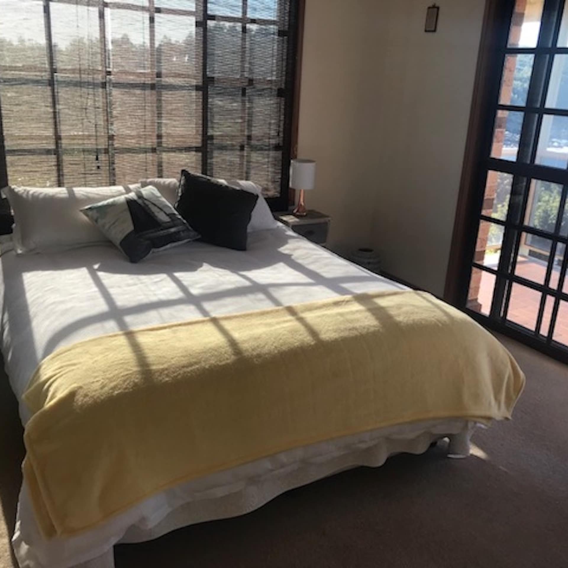 Queen bed in 5-bedroom beach cabin with sliding door entrance to balcony overlooking waterfront