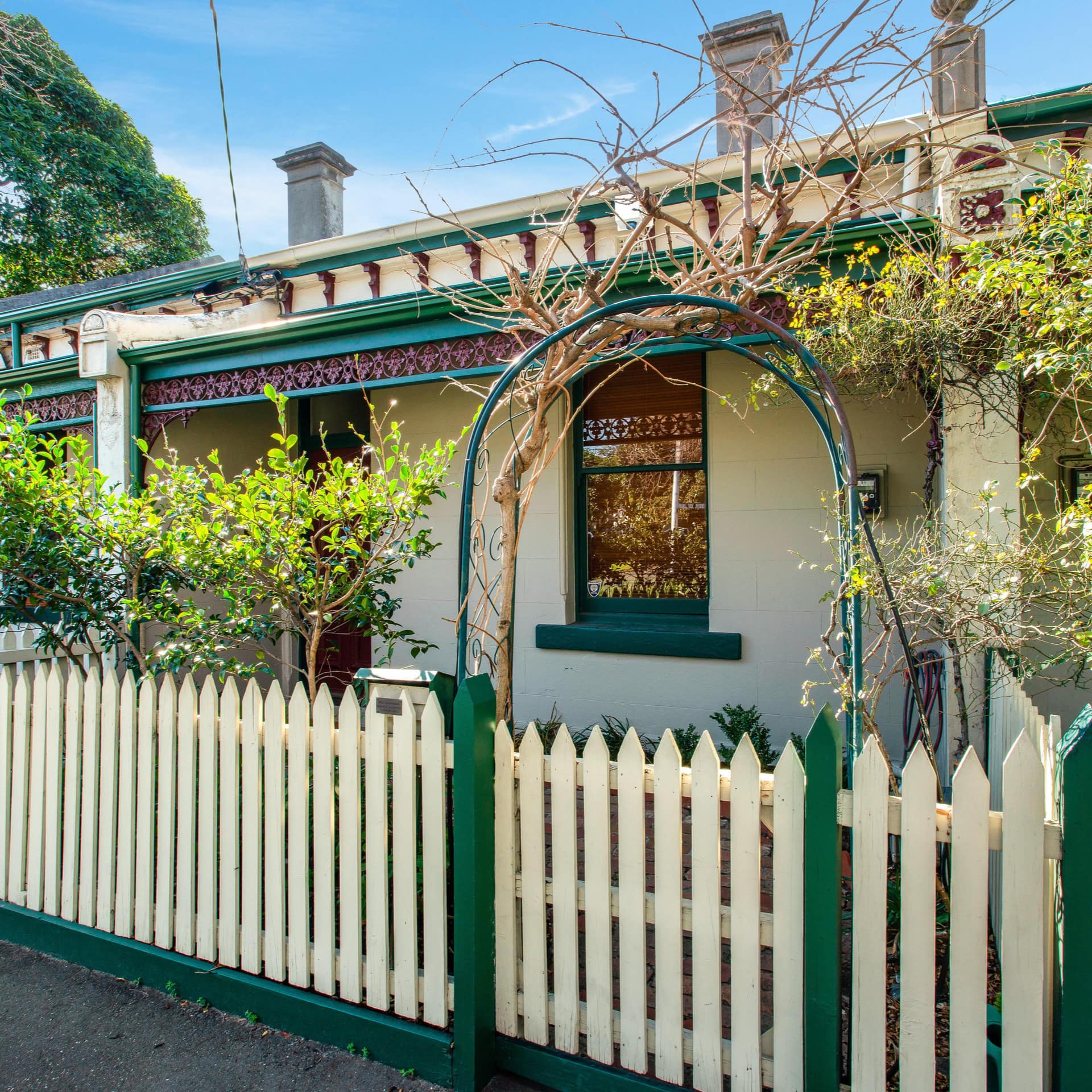 Front entrance of Melbourne terrace home with porch, front windows and brick chimneys