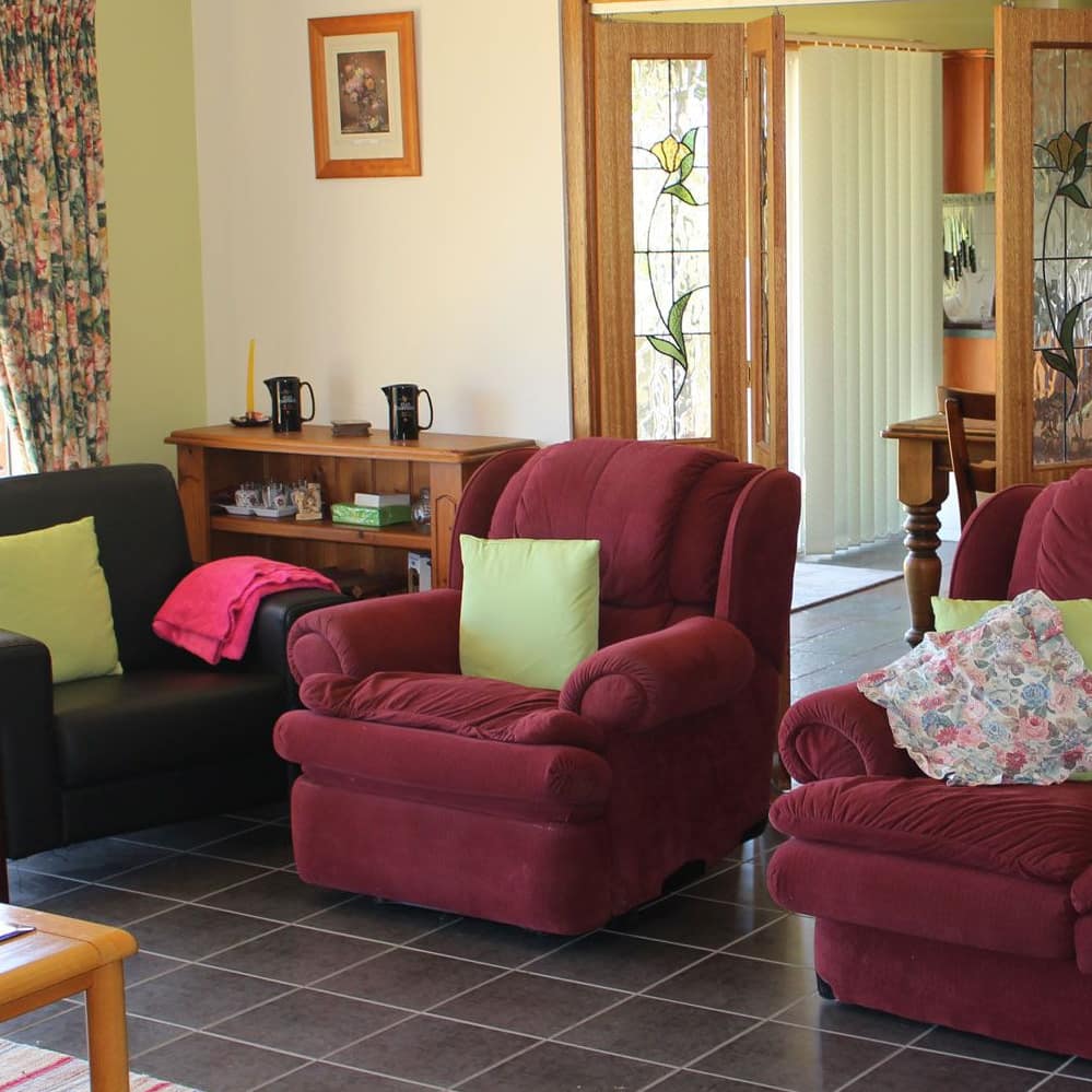 Living area of 4-bedroom lodge with red sofas and black chair