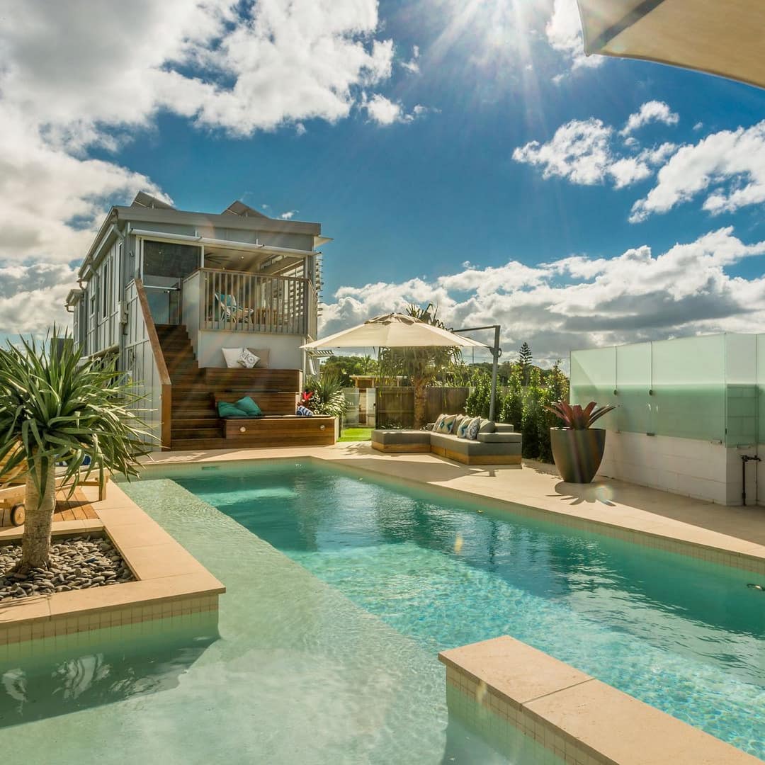 Bluewater House, a 4-bedroom beach house overlooking clear pool with deep and shallow waters and patio with outdoor seating