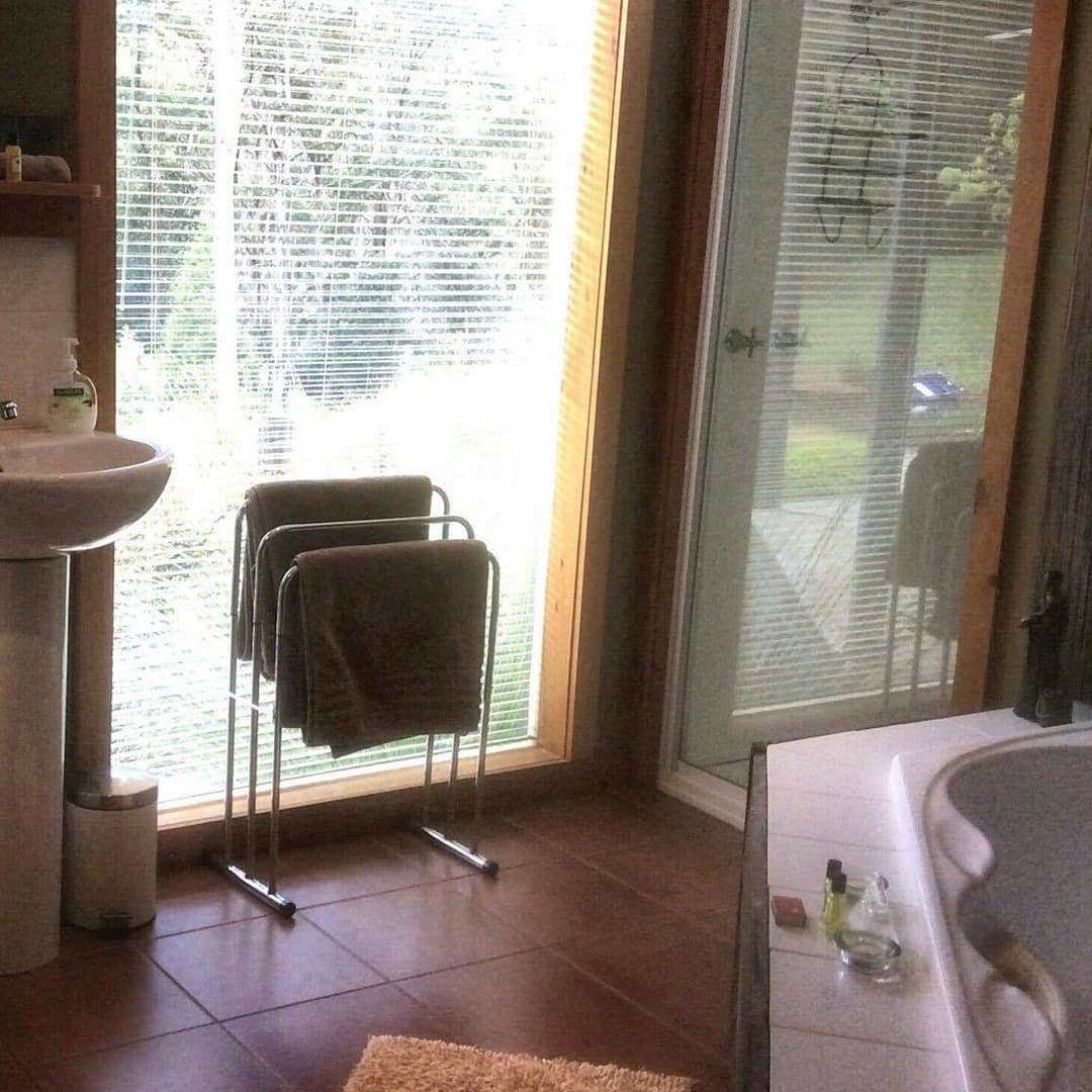 Luxury bathroom with a spa tub, glassed-in shower and single sink