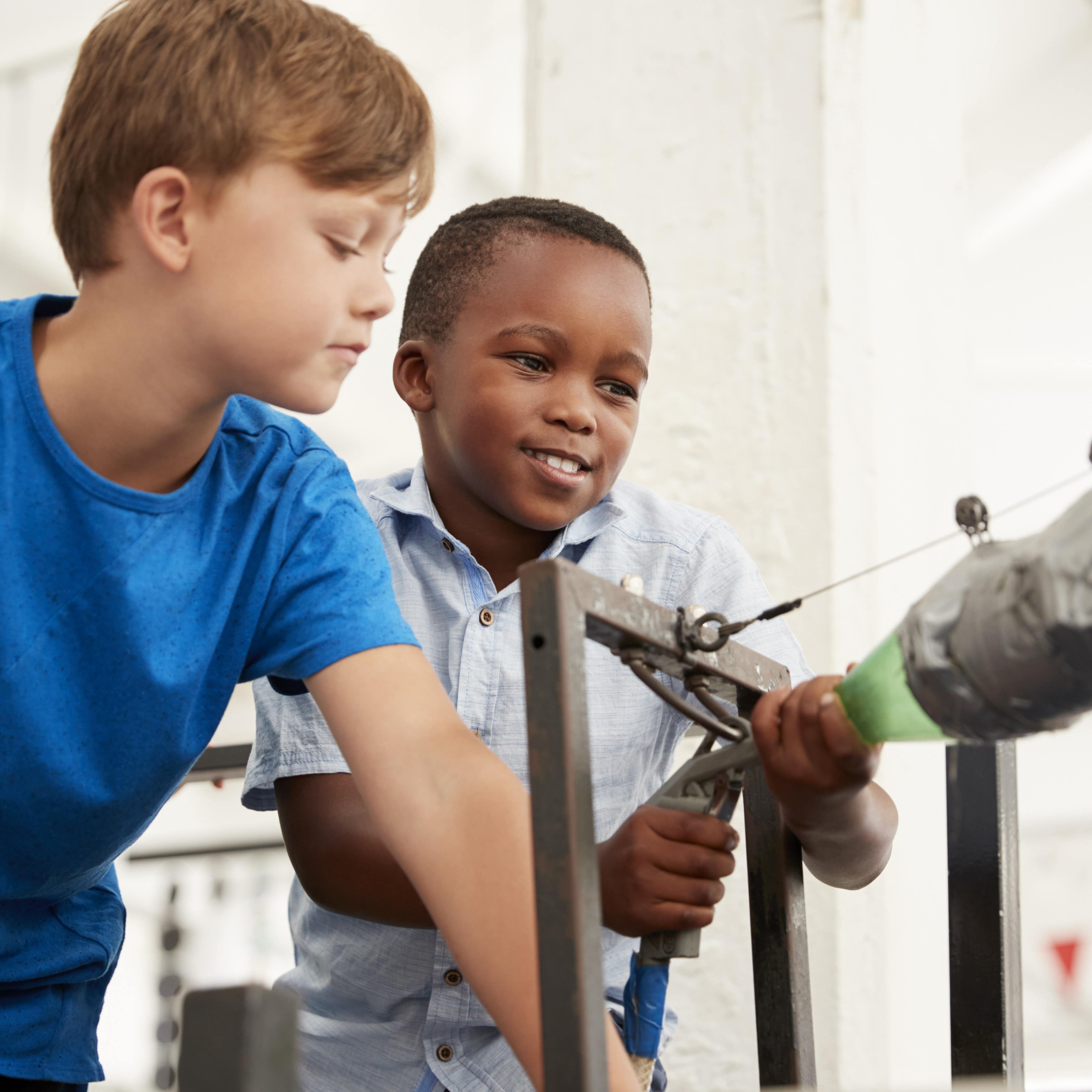 Two schoolboys using air pressure rocket at a science centre