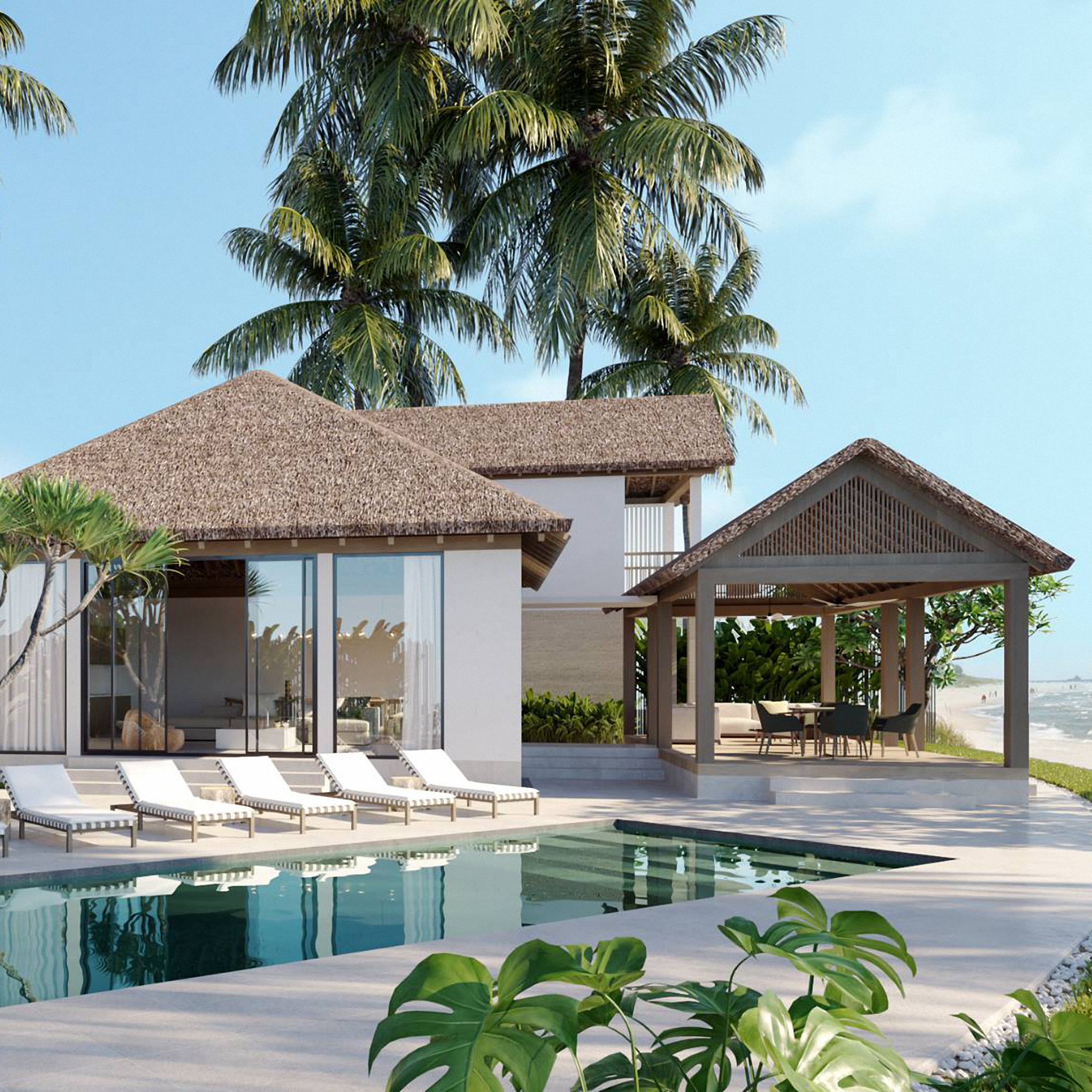 Private Bali villa with thatched roofs, a cabana with a dining table and a pool with a lounge area on the beachfront