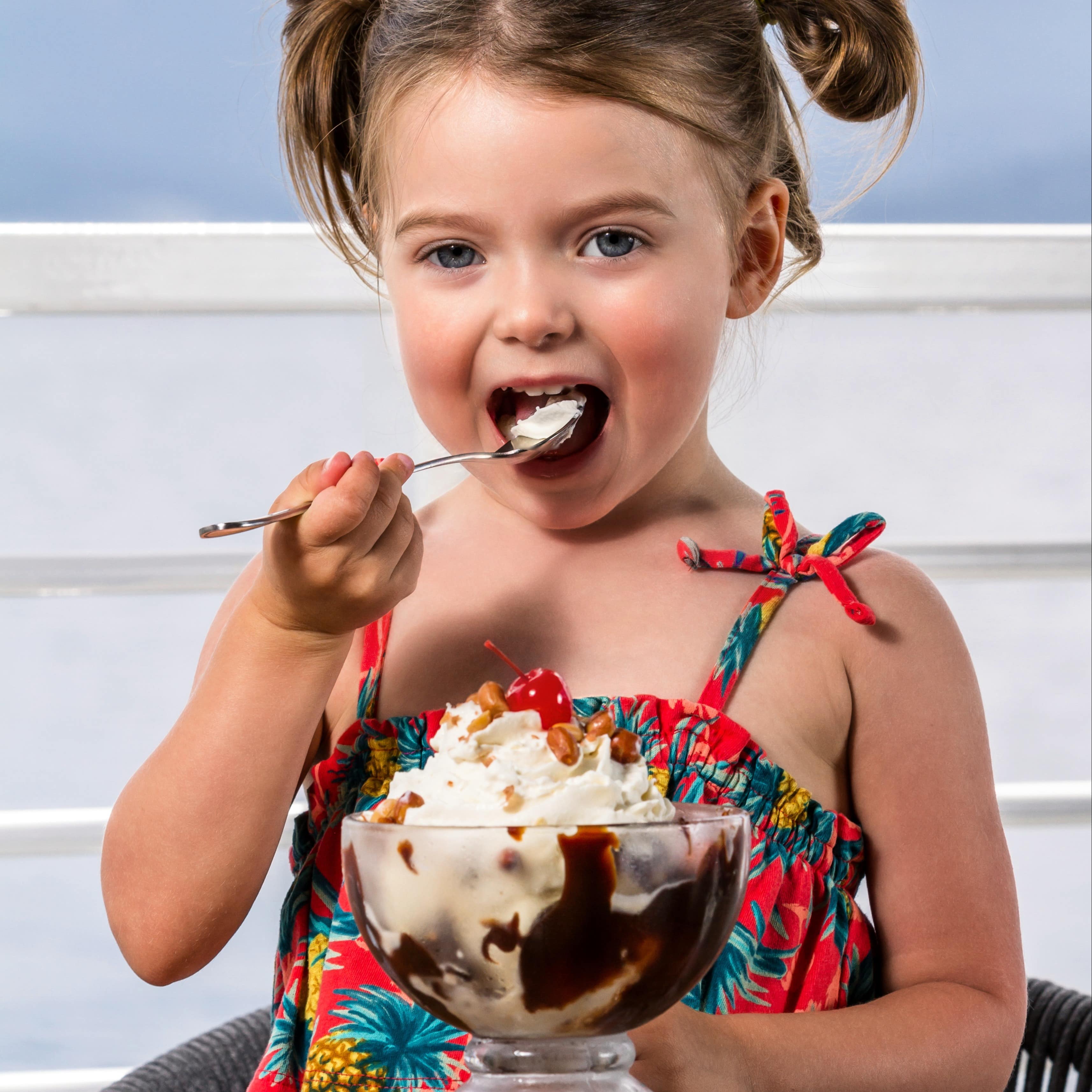 Little girl eating ice cream sundae