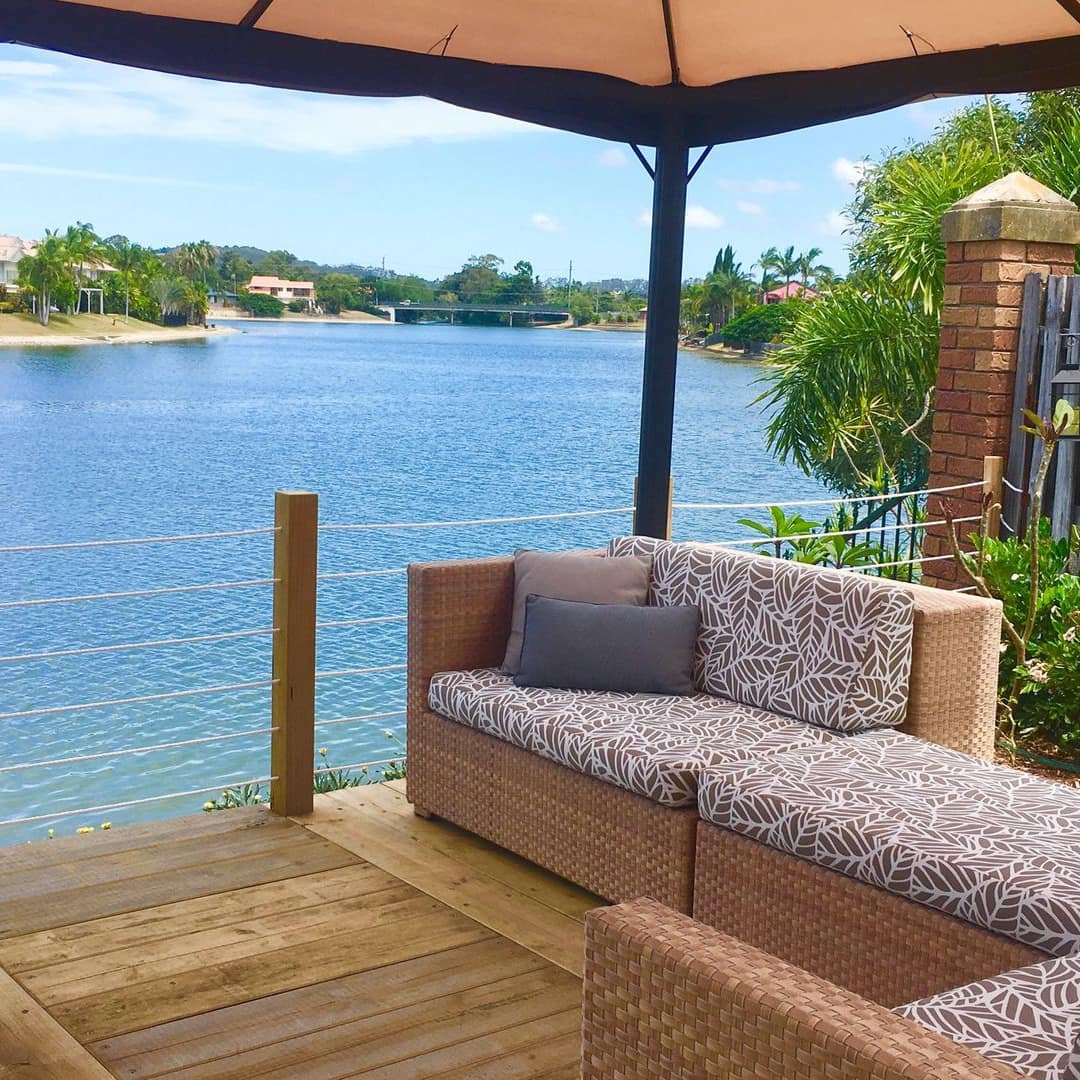Comfortably furnished hardwood patio right on the water with canopy