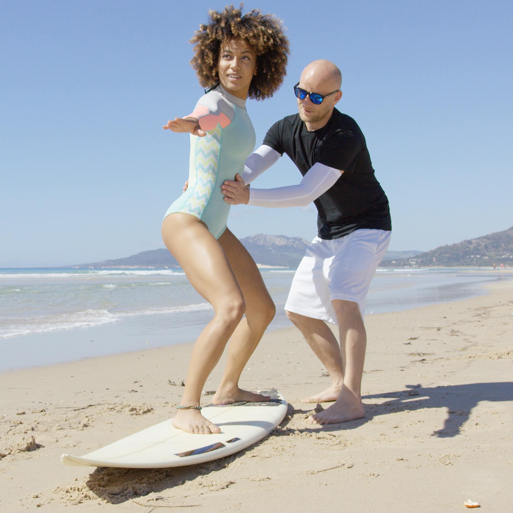 Woman getting surfing lesson on beach
