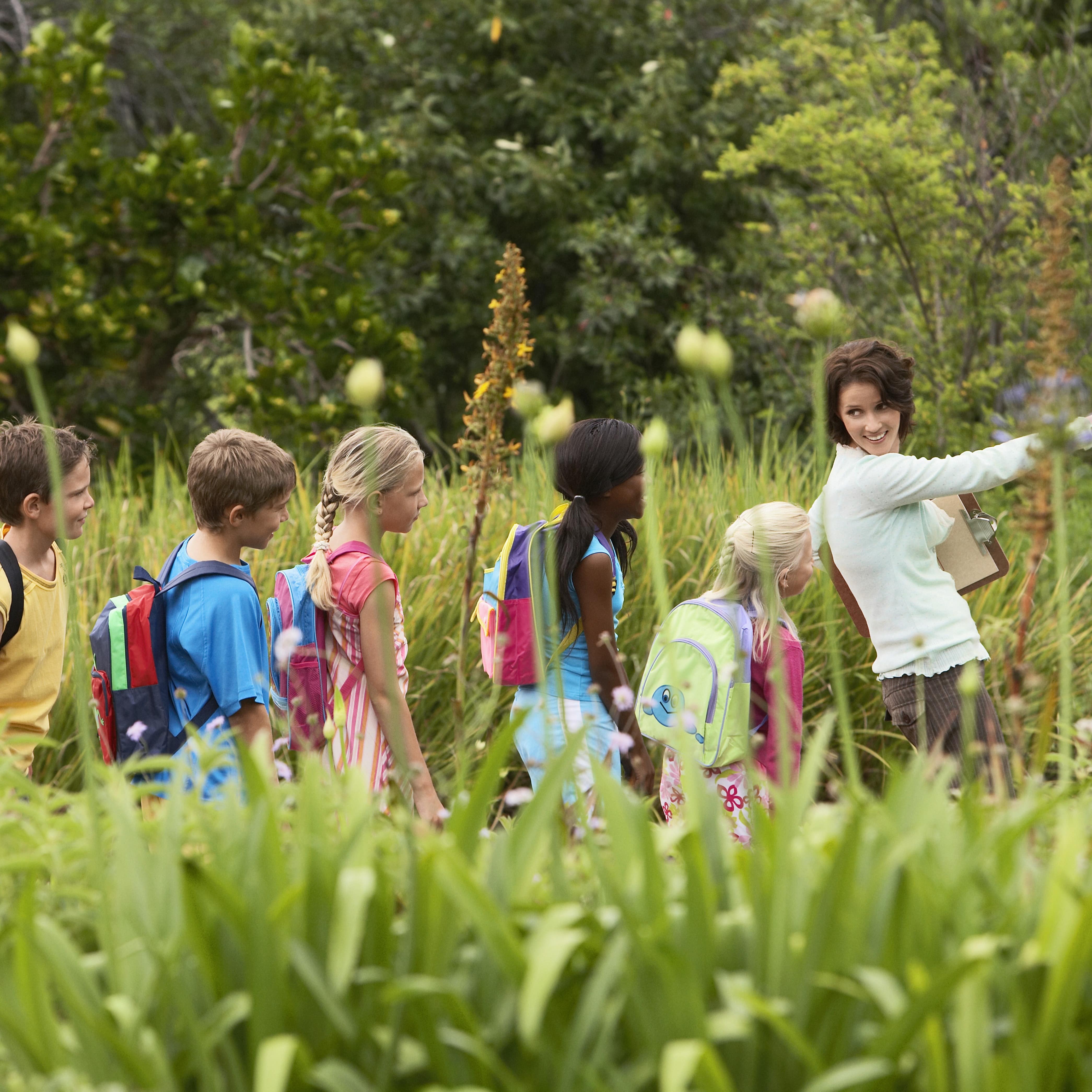Teacher leading a group of students on a nature walk