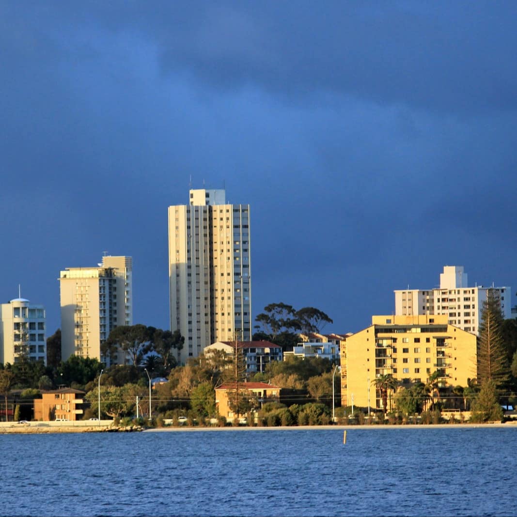 Skyline of Fremantle on a bright blue day with deep waters, shoreline and high rise buildings