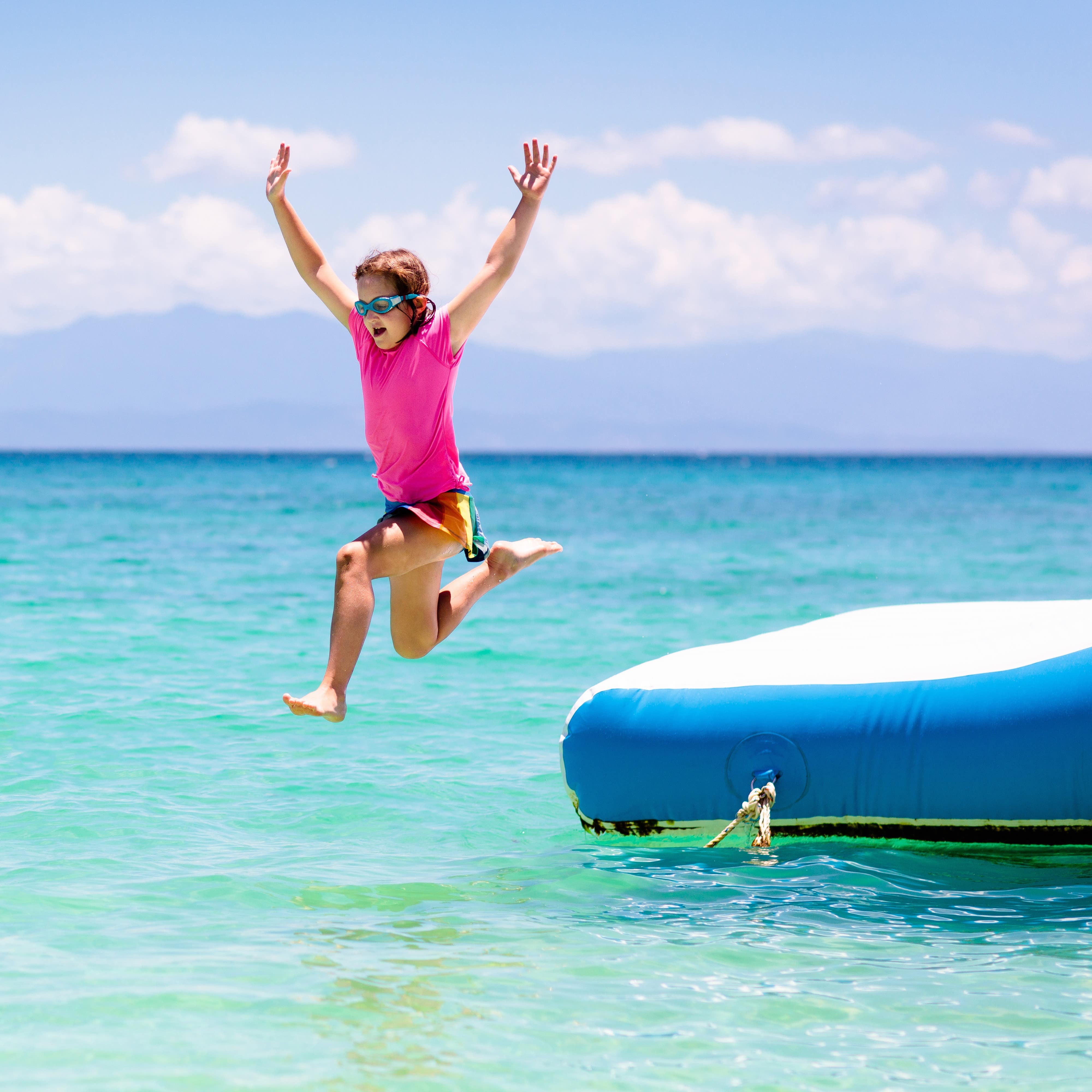 Girl jumping off of inflatable trampoline