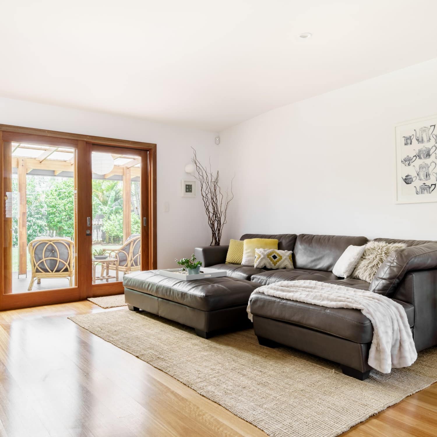Spacious living area with large sectional couch and matching ottoman with sliding glass doors